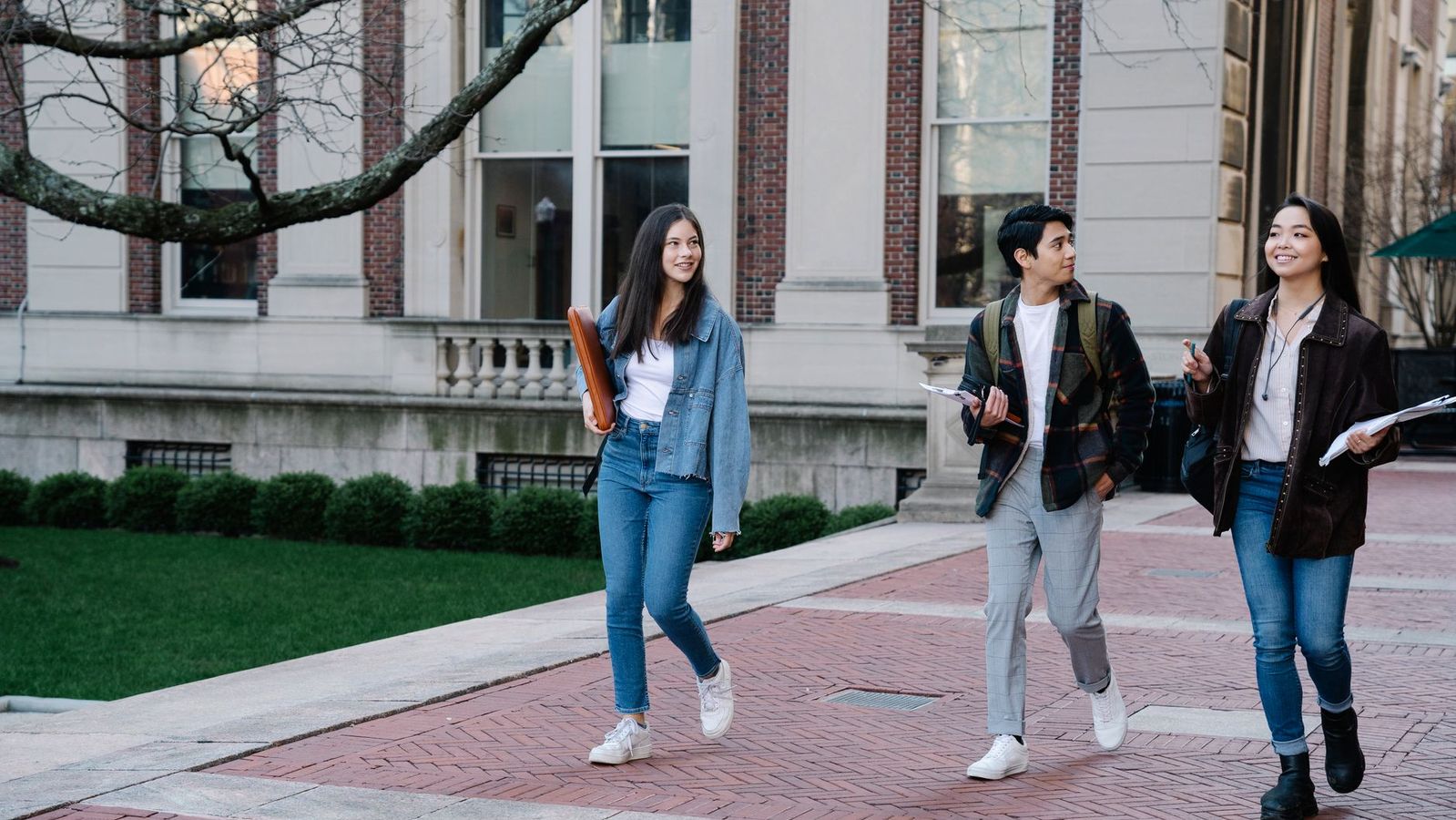 College students walking on a sidewalk near campus apartment housing