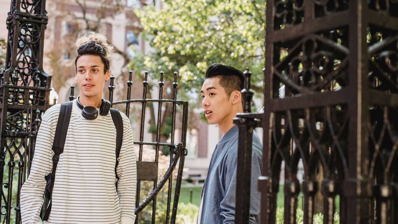 Students talking near the gated entrance of a university building