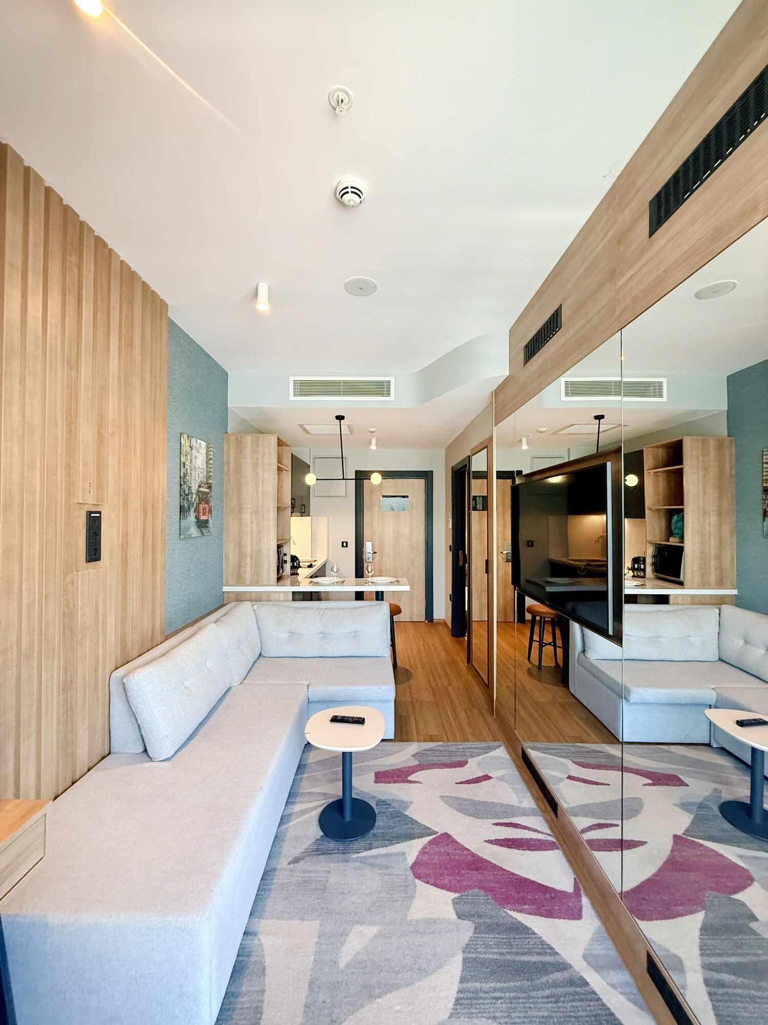 CITYLOFT 175 One Bedroom: Uzun salon, beyaz köşe kanepe ve açık mutfak