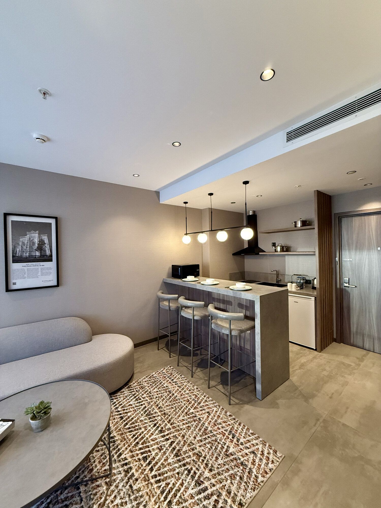 CITYLOFT 147 One Bedroom Suite: Kanepe, bar tezgâhı ve mutfak köşesi