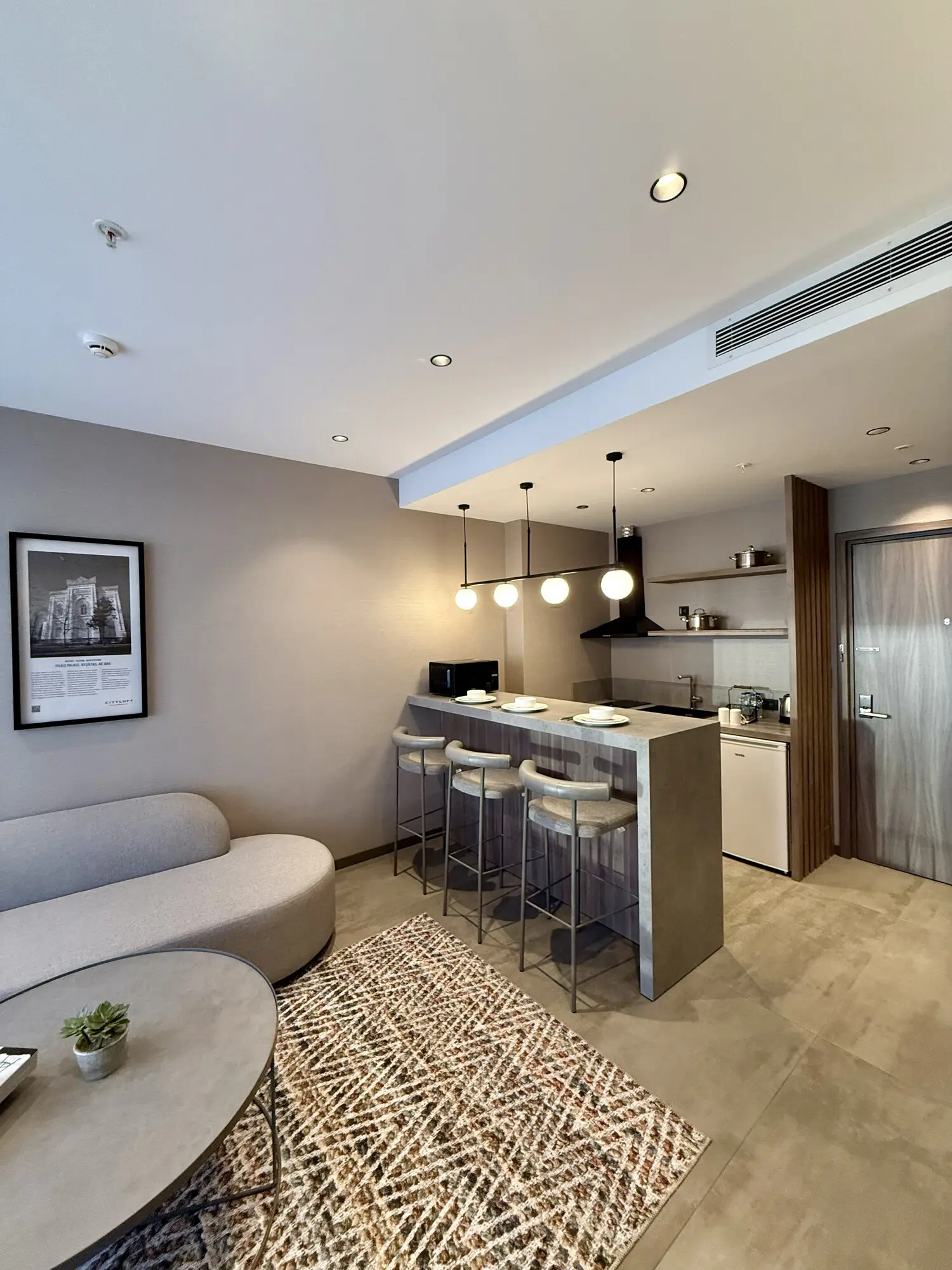 CITYLOFT 147 One Bedroom Suite: Kanepe, bar tezgâhı ve mutfak köşesi