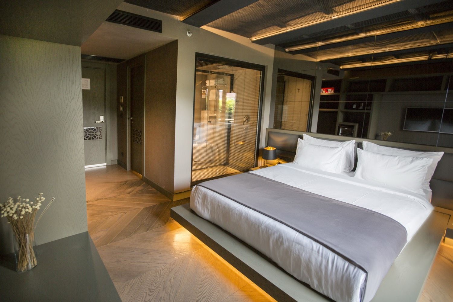 CITYLOFT 81 Deluxe Suite with Terrace: Işıklı platformda yatak ve cam bölmeli banyo