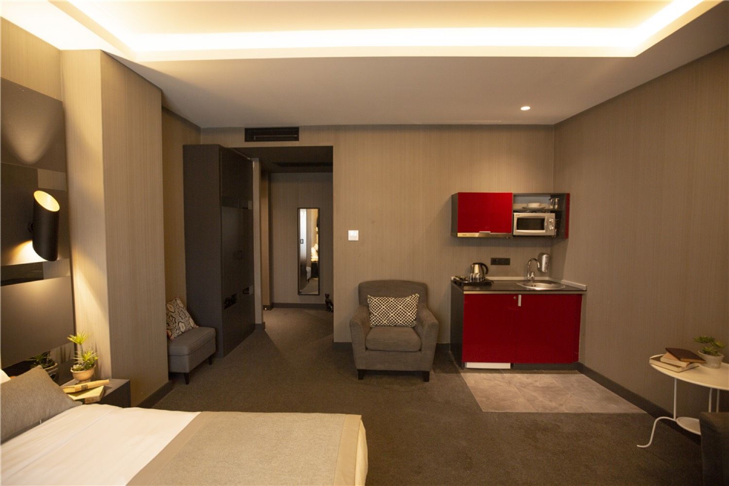 CITYLOFT 24 Junior Jacuzzi Suite: Doppelbett und Kochnische mit roten Schränken