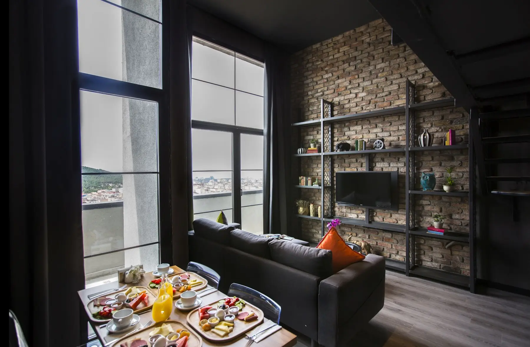 CITYLOFT 161 Loft Suite: Kahvaltı masası, kanepe ve tuğla duvarda raf ünitesi