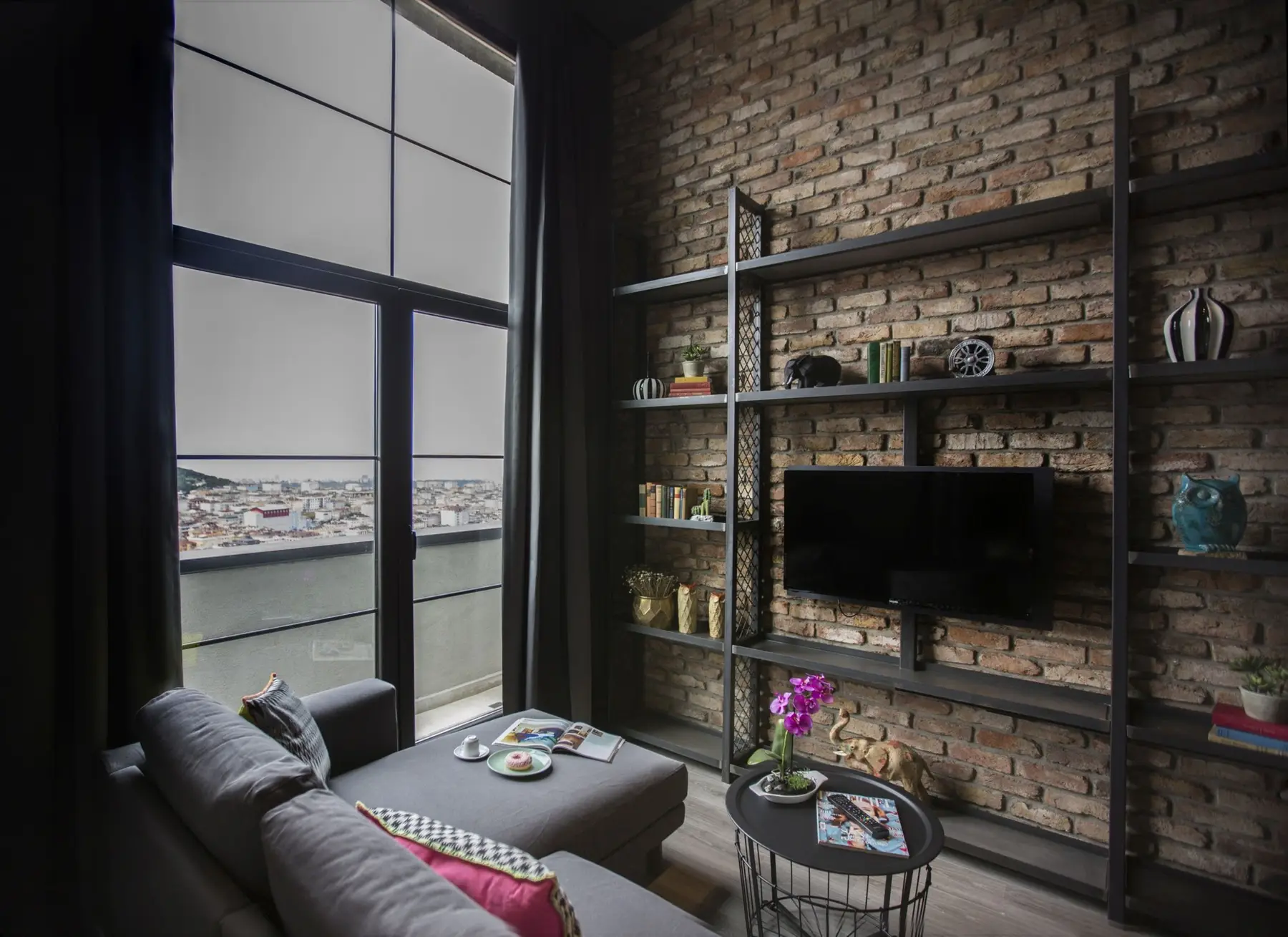 CITYLOFT 161 Loft Suite: Tuğla duvarda raf ünitesi, TV ve köşe kanepe