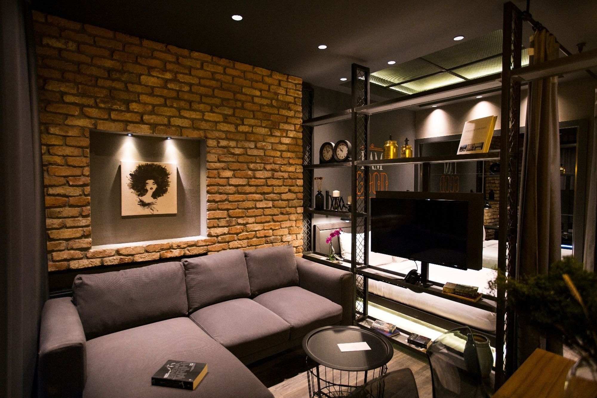 CITYLOFT 161 One Bedroom Standart: Tuğla duvar önünde köşe kanepe ve TV ünitesi