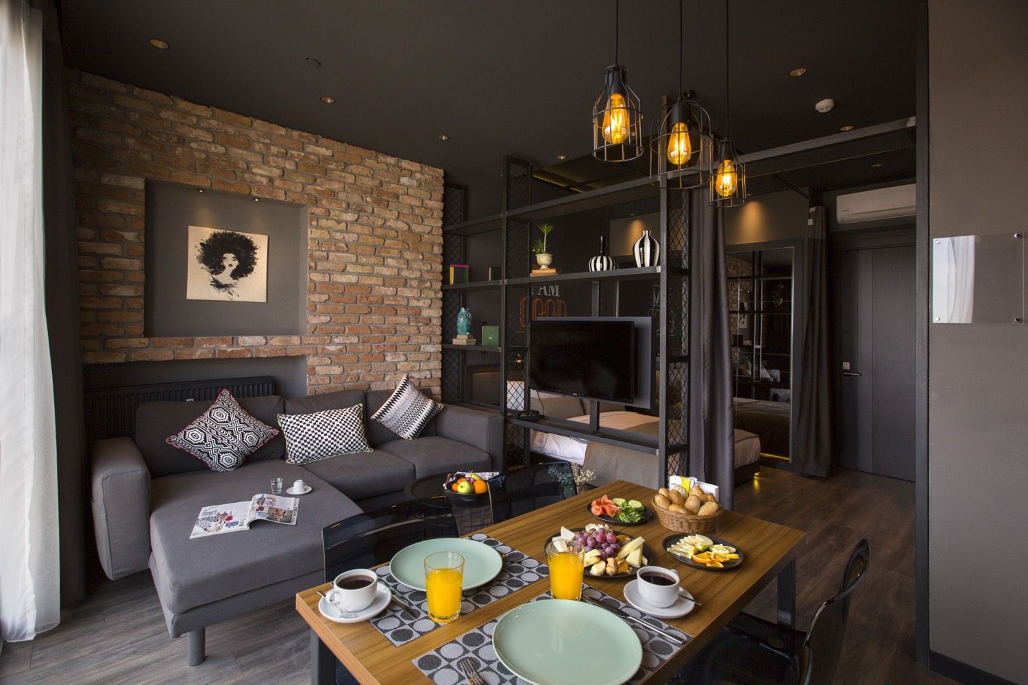 CITYLOFT 161 One Bedroom Standart: Tuğla duvarlı salon, köşe kanepe ve kahvaltı masası