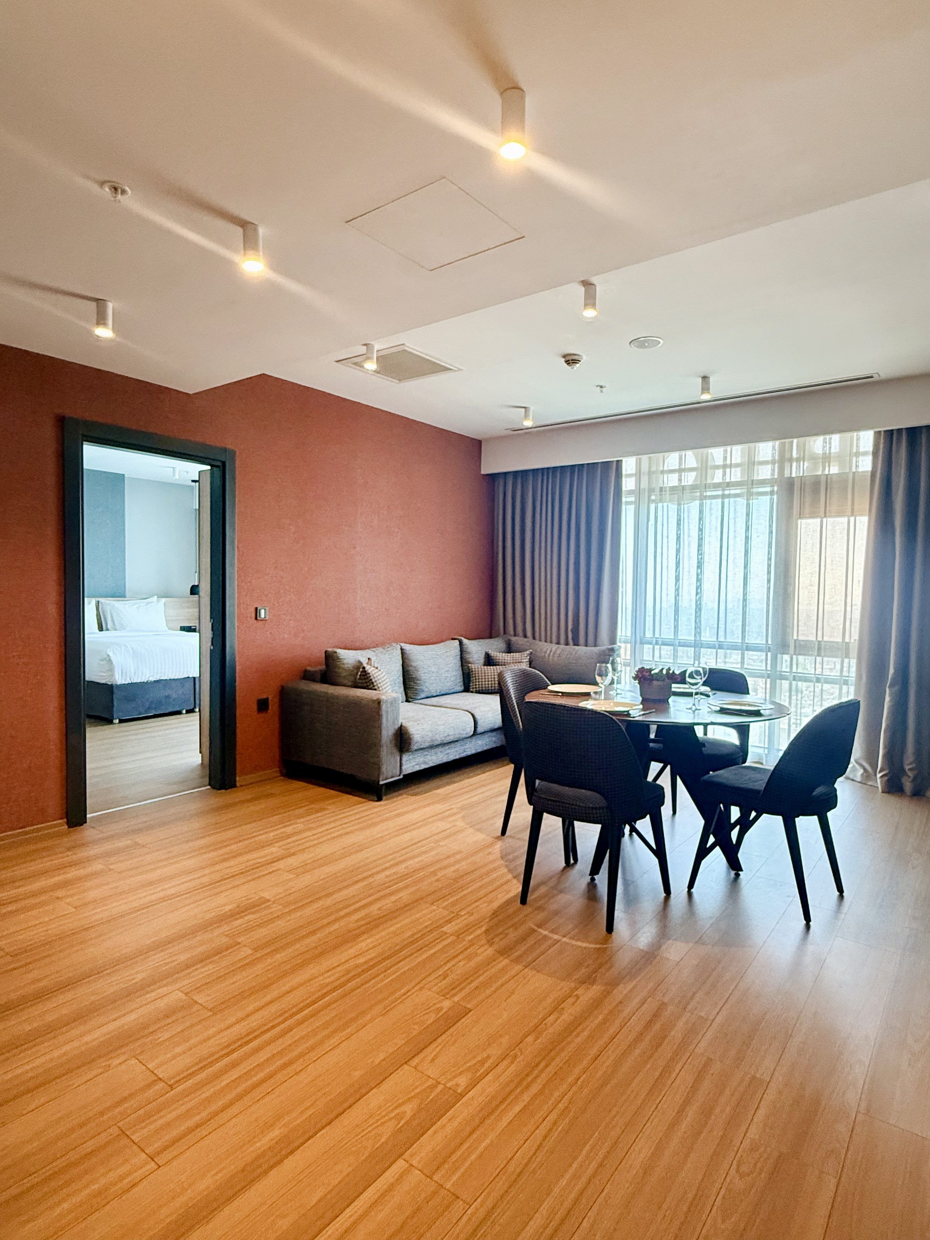 CITYLOFT 175 Jacuzzi Suite: Salon, yemek masası ve ayrı yatak odası girişi
