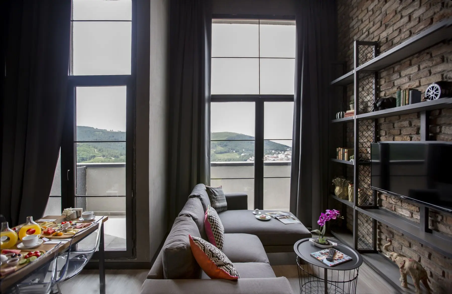 CITYLOFT 161 Loft Suite: Yüksek pencereler önünde köşe kanepe ve kahvaltı masası
