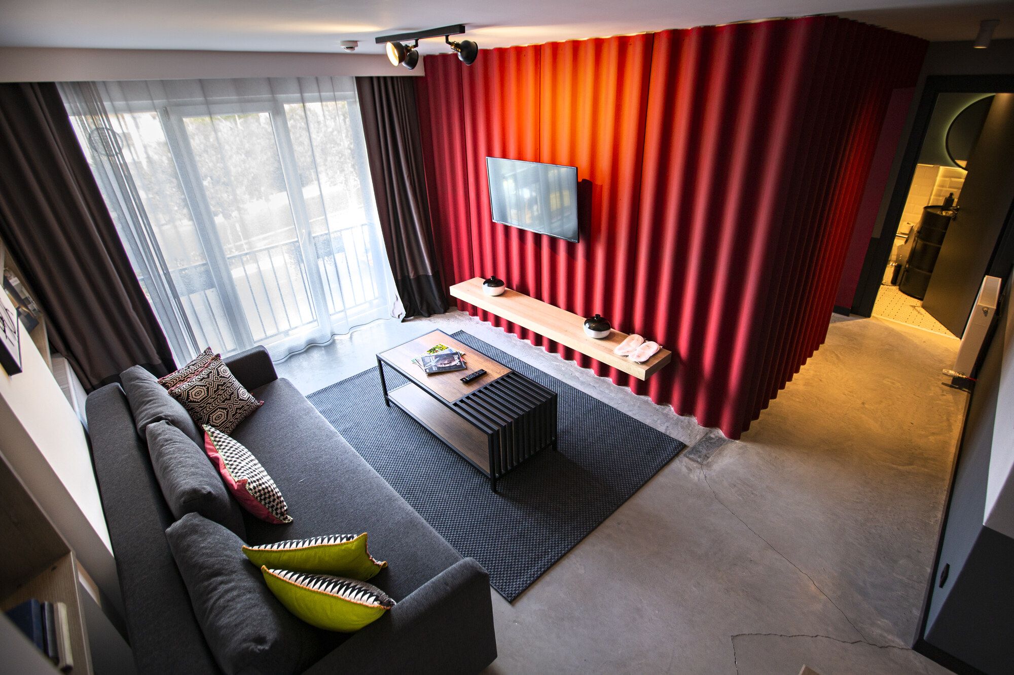 CITYLOFT 64: Kırmızı panel duvar, köşe kanepe ve TV