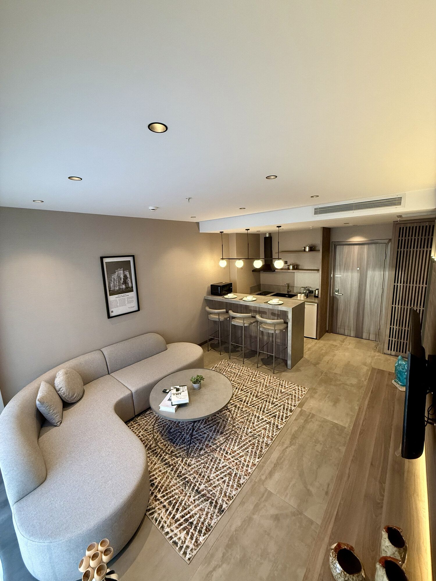 CITYLOFT 147 One Bedroom Suite: Kavisli kanepeli oturma alanı ve bar tezgâhlı mutfak