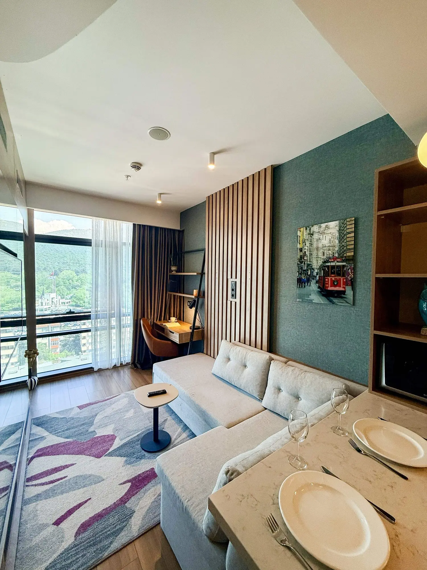 CITYLOFT 175 One Bedroom City: Pencere önünde kanepe ve servis hazırlanmış yemek tezgâhı