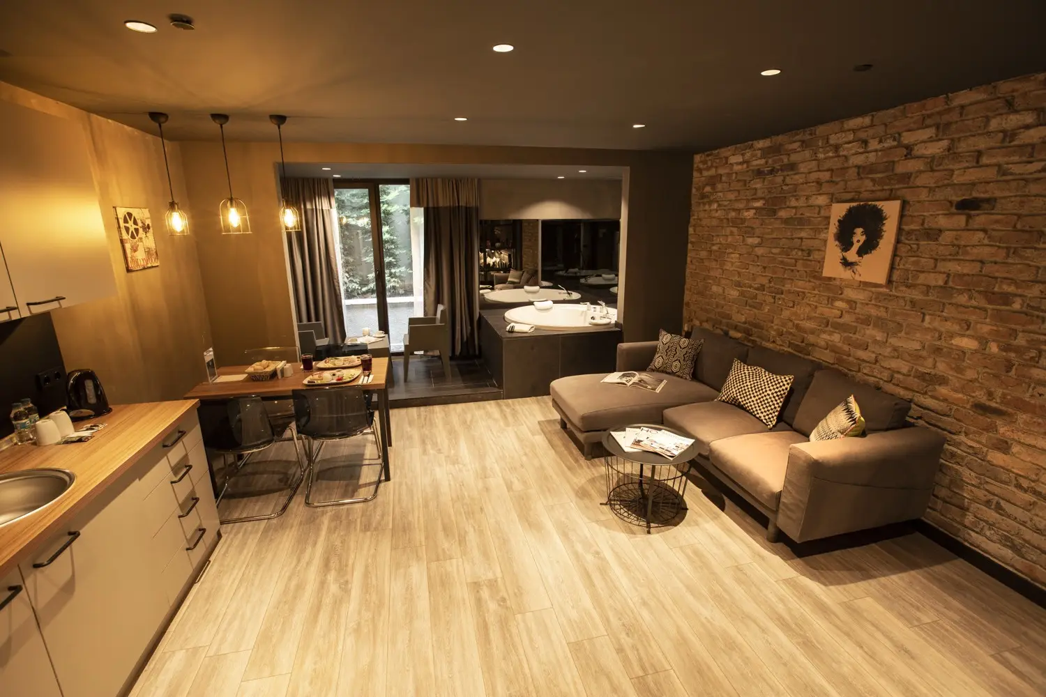 CITYLOFT 161 Jacuzzi Suite: Mutfak, yemek masası ve tuğla duvar önünde kanepe