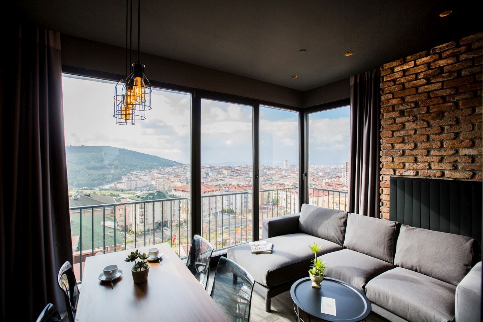 CITYLOFT 161 Corner Suite: İki cepheden ışık alan salon, kanepe ve tuğla duvar