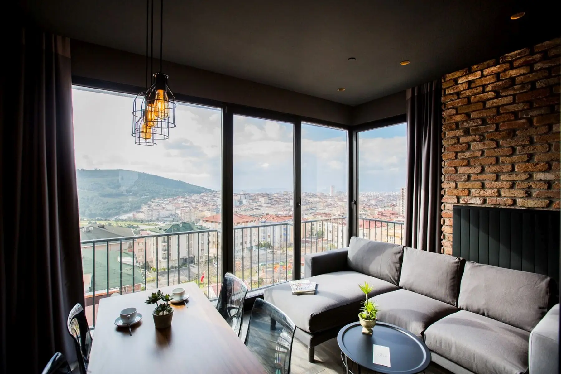 CITYLOFT 161 Corner Suite: İki cepheden ışık alan salon, kanepe ve tuğla duvar
