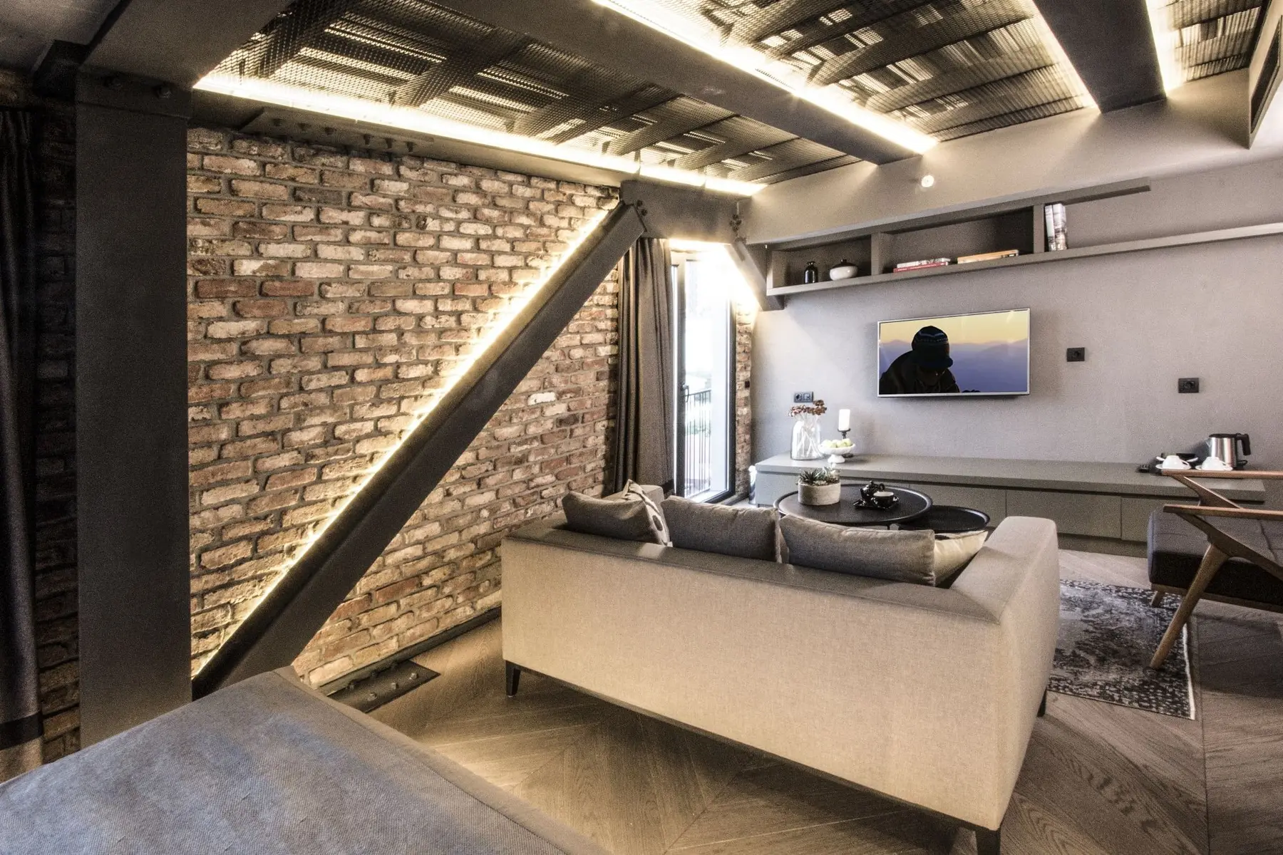 CITYLOFT 81 Loft Suite: Tuğla duvar önünde kanepe ve çalışma masası