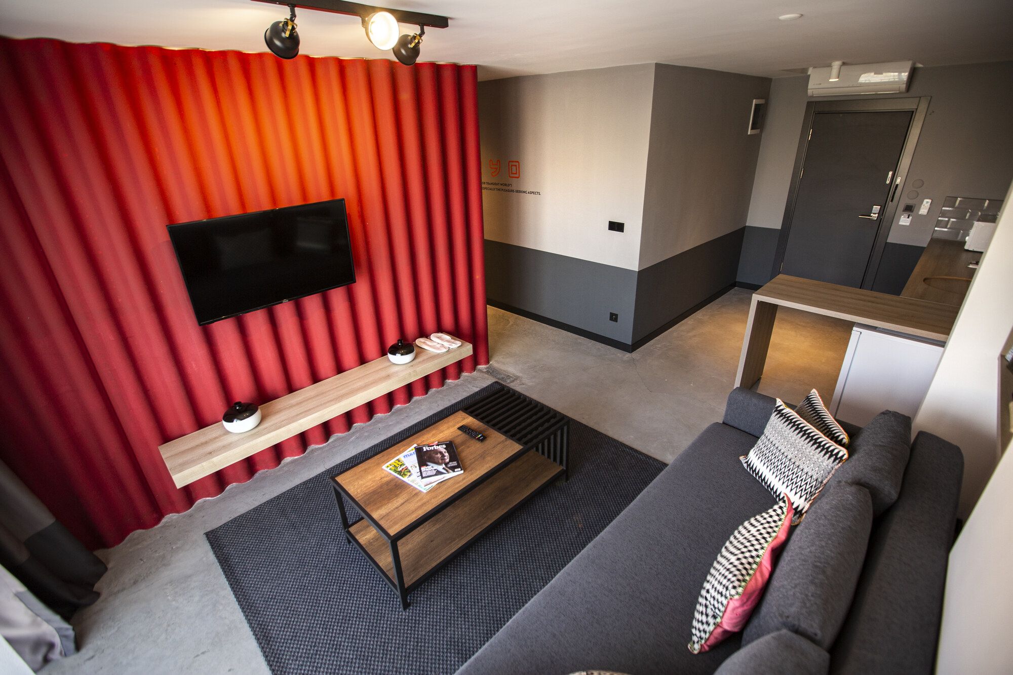 CITYLOFT 64 Garden Studio: Kırmızı panel duvarda TV ve köşe kanepe