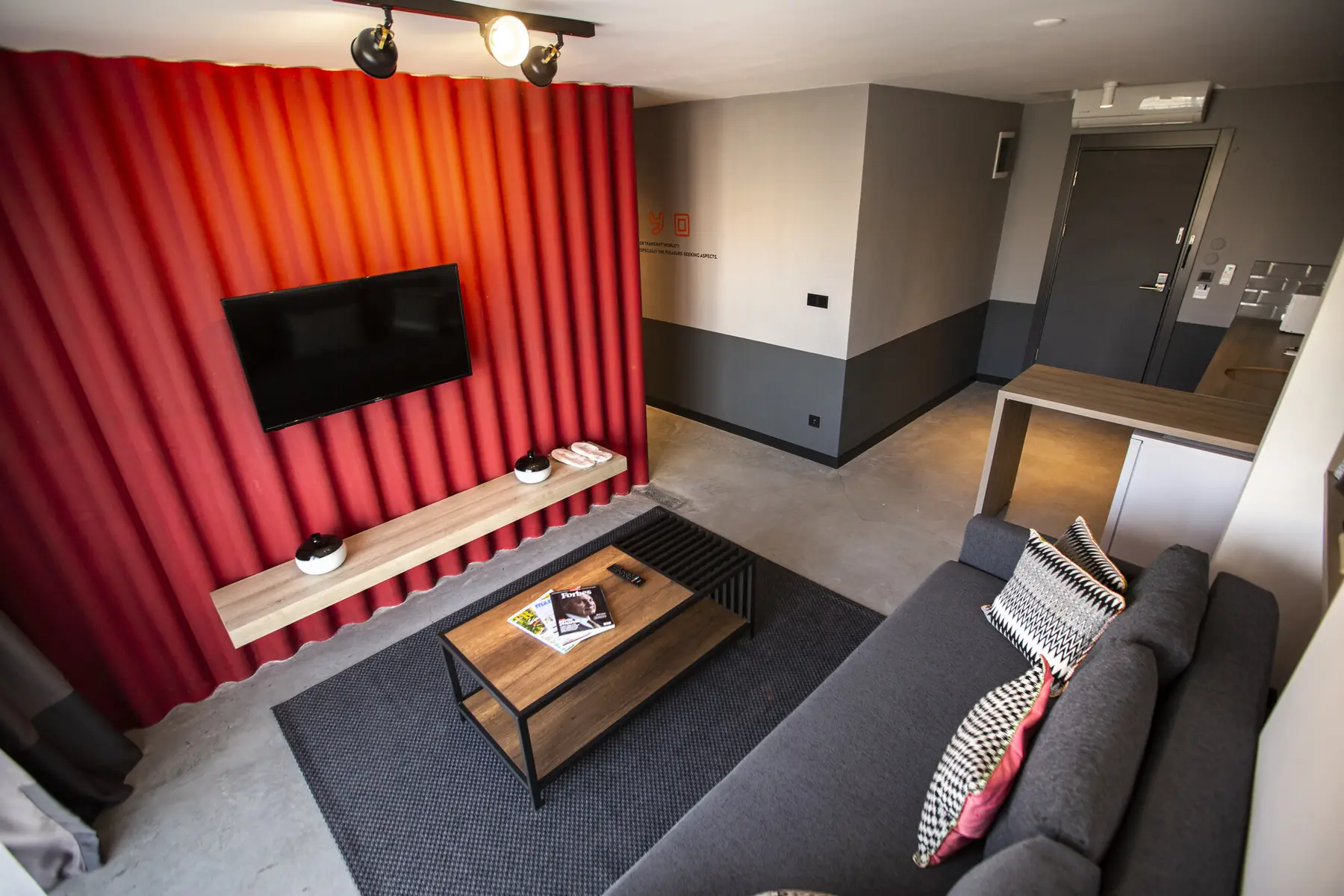 CITYLOFT 64 Garden Studio: Kırmızı panel duvarda TV ve köşe kanepe