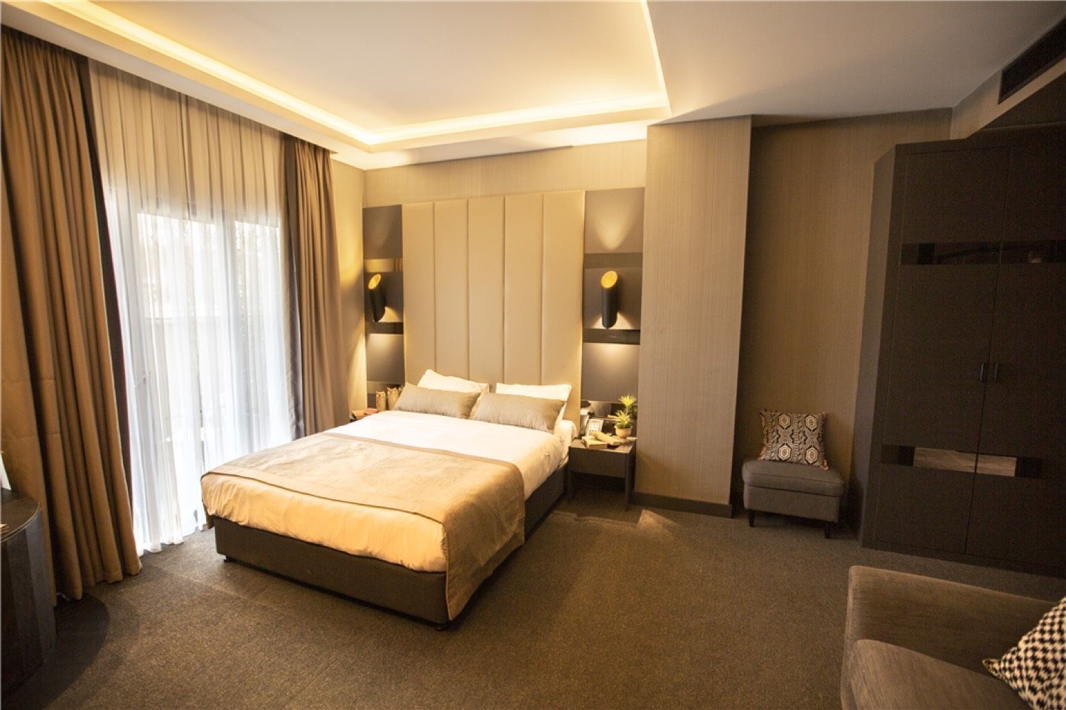 CITYLOFT 24 Junior Jacuzzi Suite: Doppelbett und Sessel am Fenster
