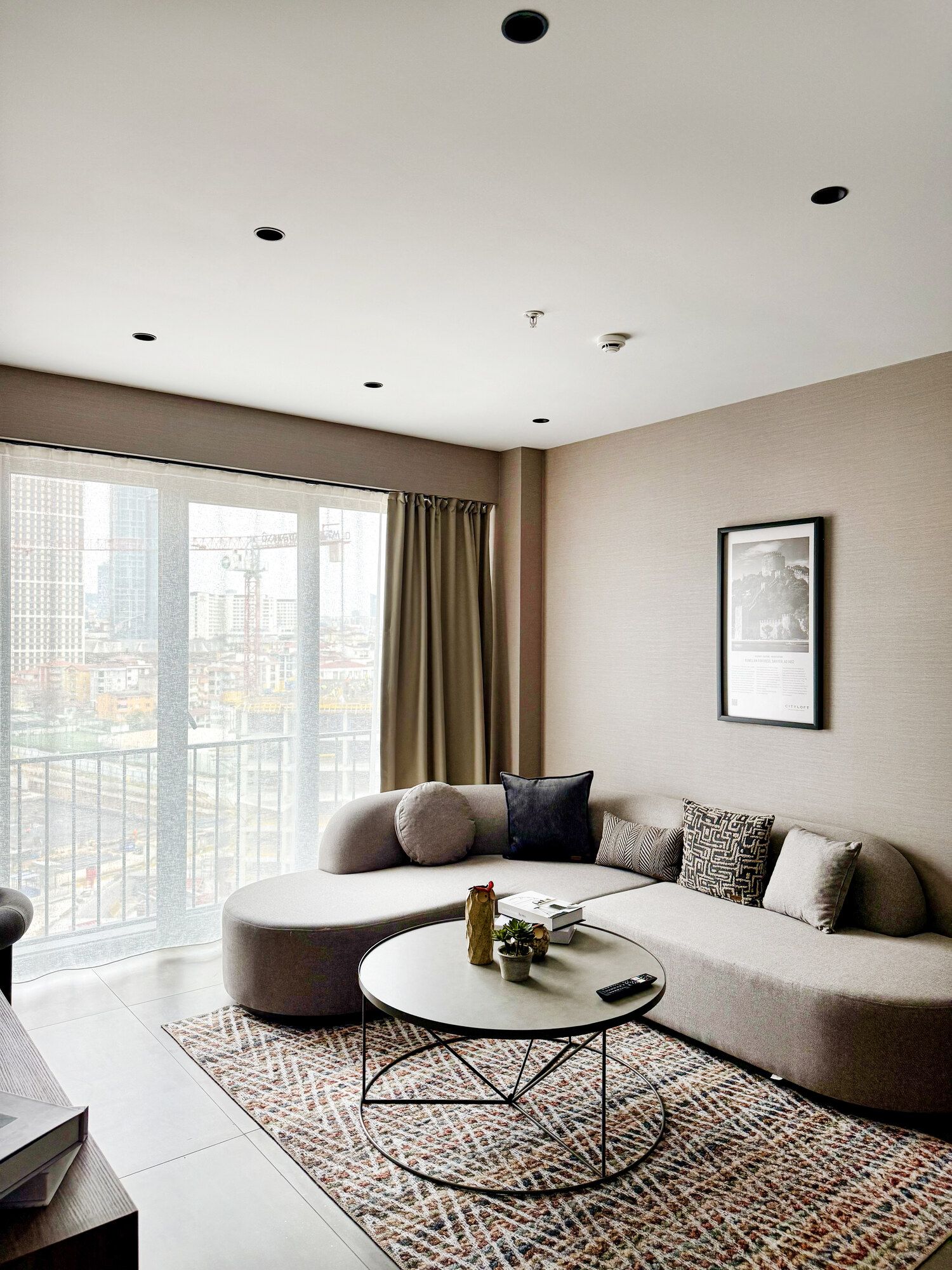 CITYLOFT 147 One Bedroom Suite: Geniş pencereli salon, kavisli kanepe ve şehir manzarası