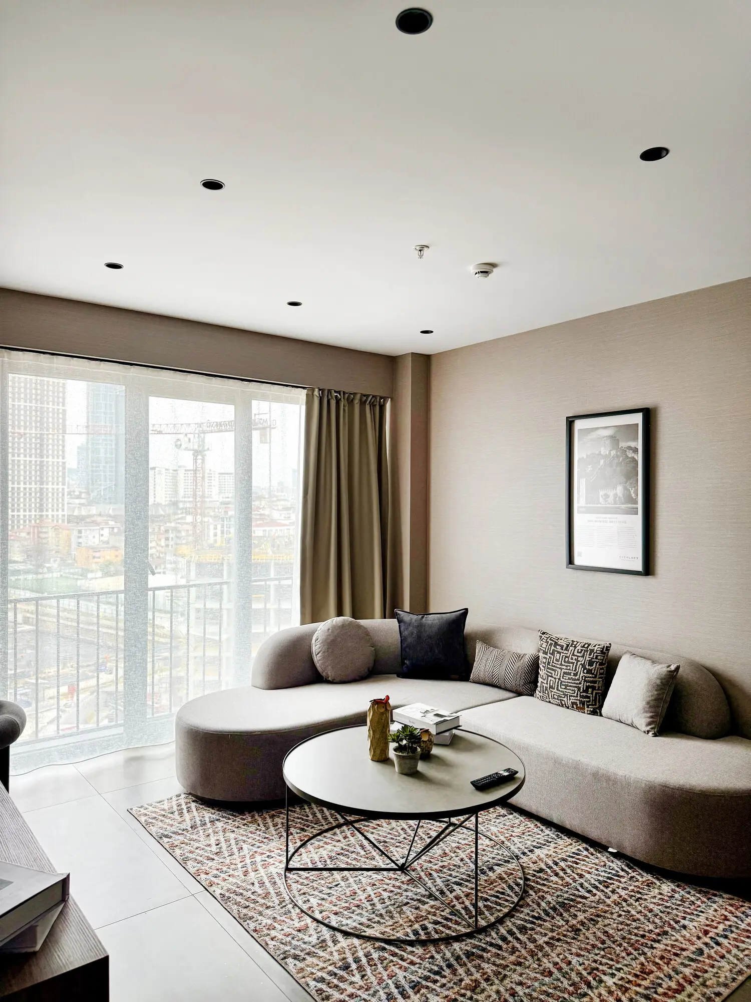 CITYLOFT 147 One Bedroom Suite: Geniş pencereli salon, kavisli kanepe ve şehir manzarası