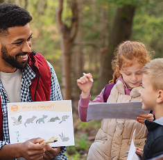 Teacher talks to students in the forest.