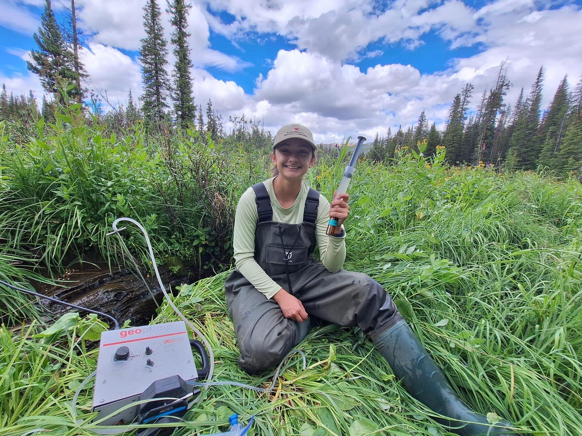 Photo of GSA Graduate Student Research Grant Recipient conducting geoscience research fieldwork with equipment in wetlands