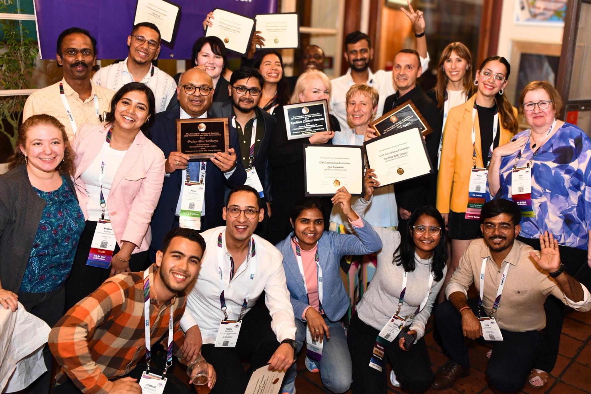 GSA Travel Grant recipients holding up award certificates at GSA International reception at Connects 2025
