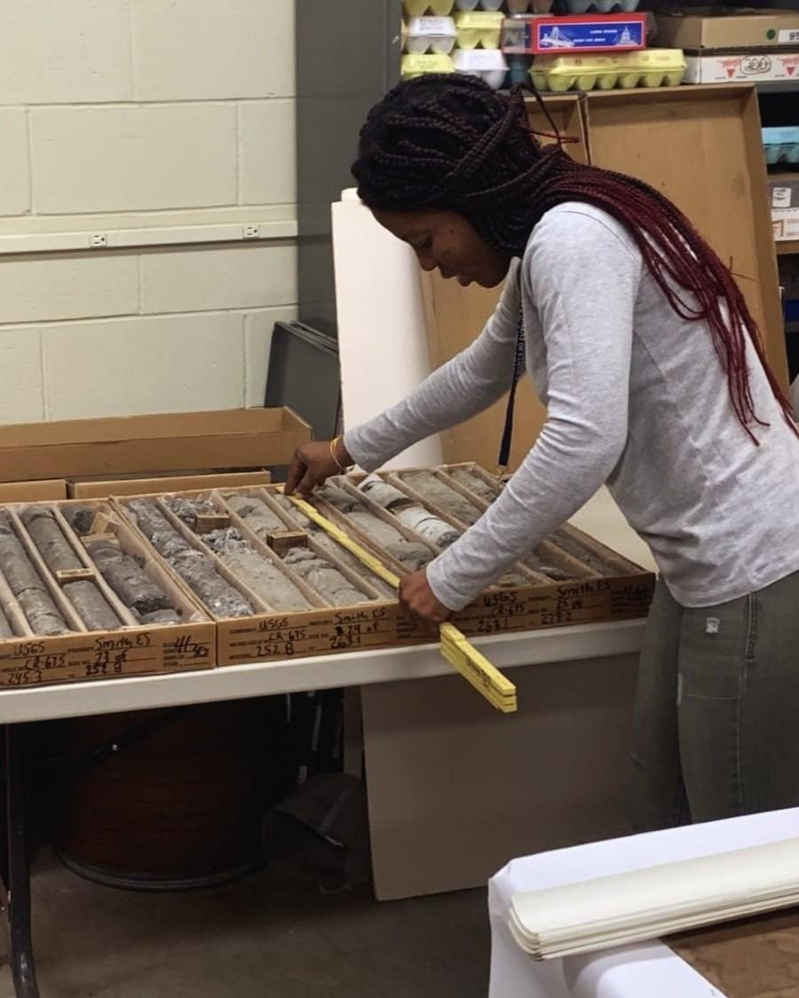 Photo of GSA graduate student research grant recipient conducting geoscience research in the lab on rock core samples