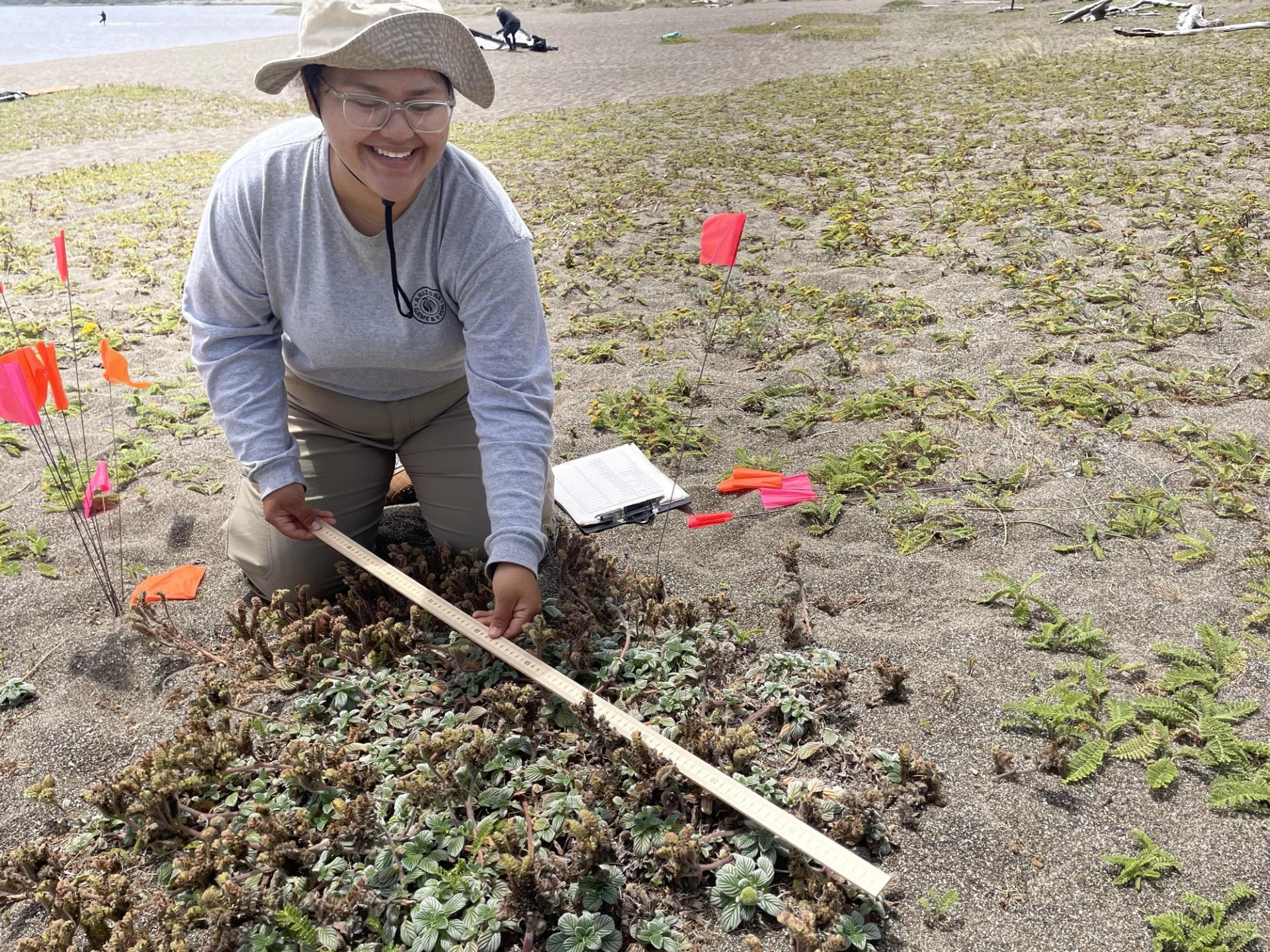 Photo of GeoCorps Participant in the field taking a measurement
