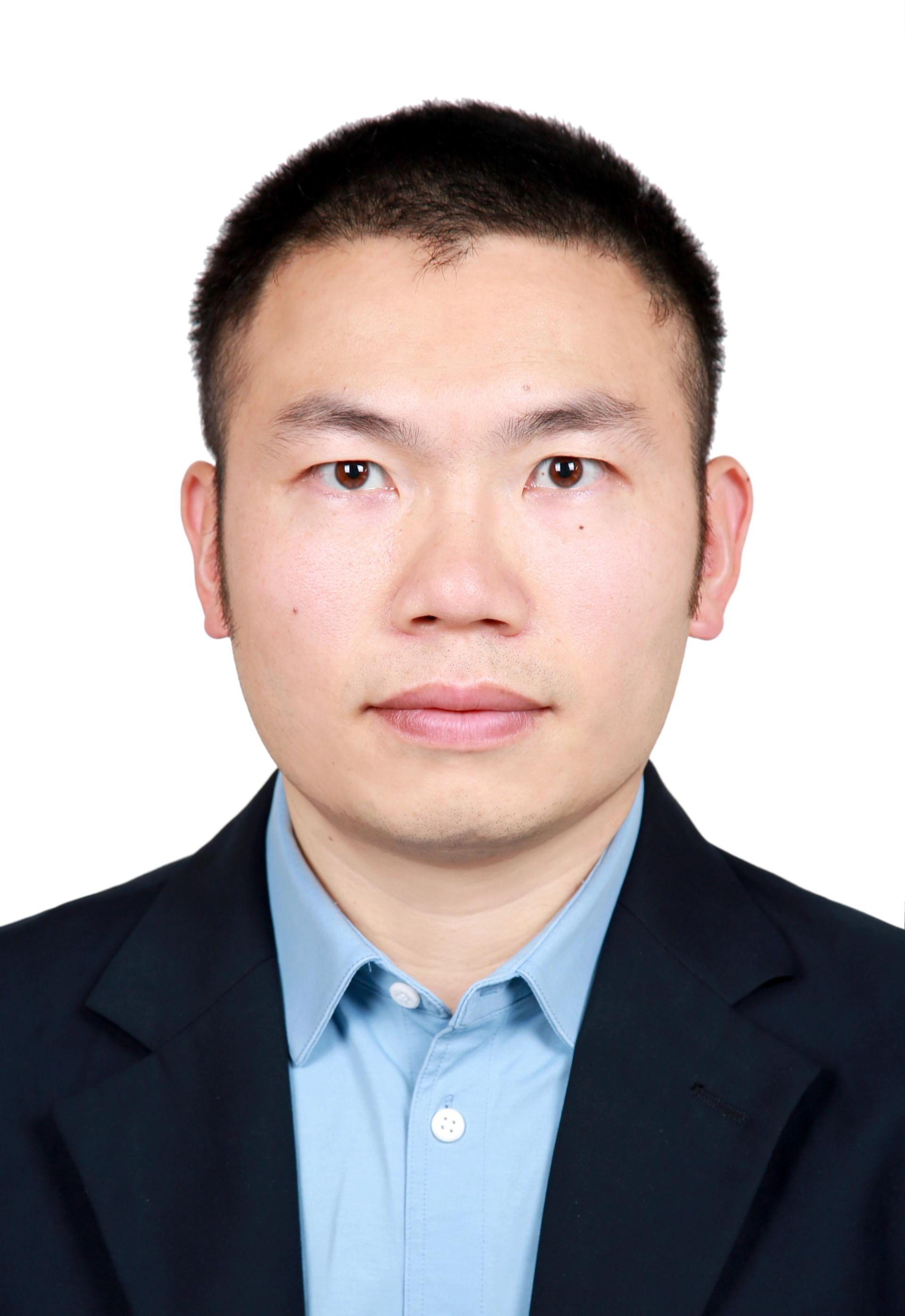 Dongfang Song against a white background and in a dark jacket and light blue, button-down collared shirt.