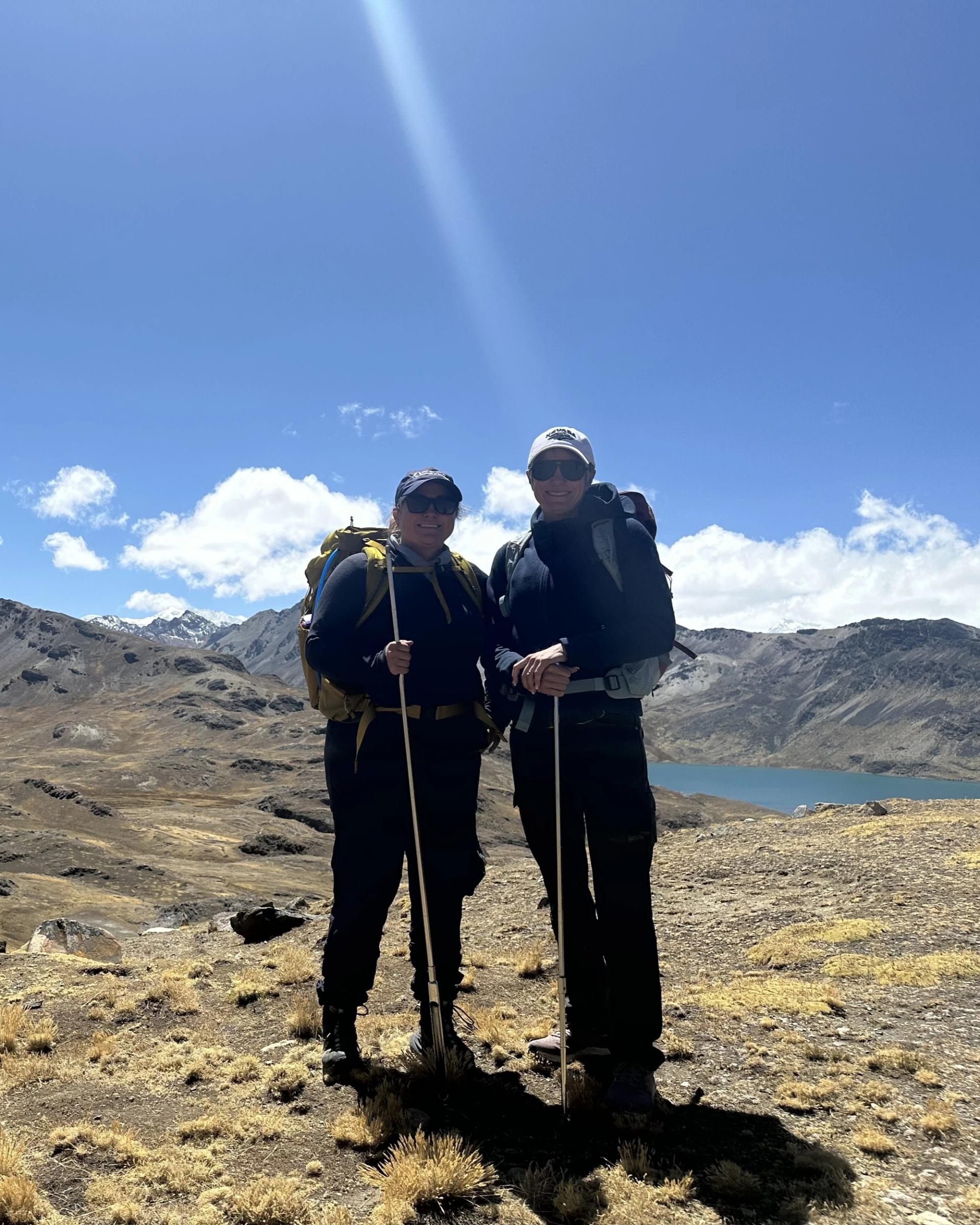 Photo of GSA Graduate Student Research Grant Recipients conducting geoscience research in the field with mountains and lake in background
