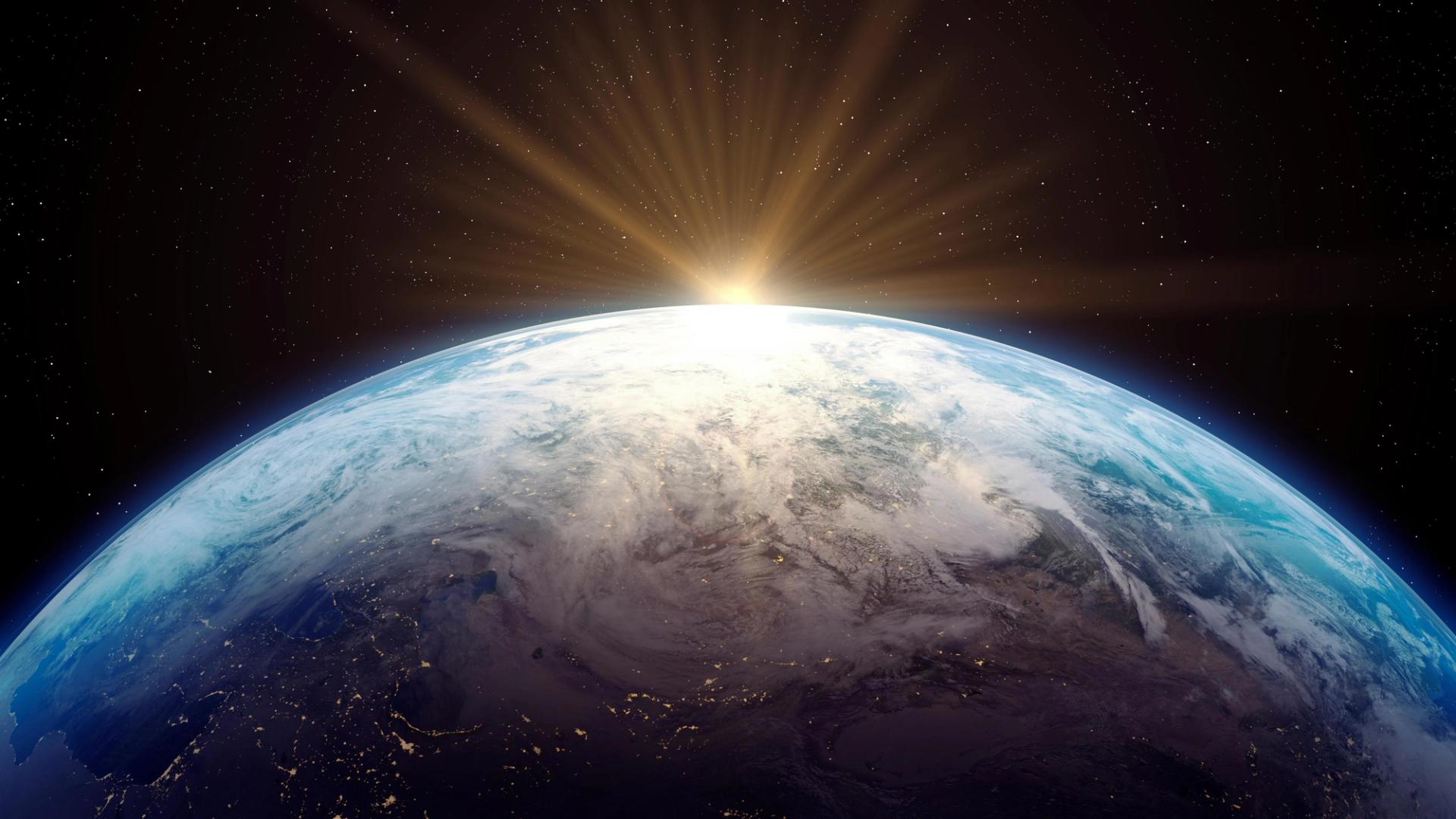 Sun rising behind planet Earth view from space