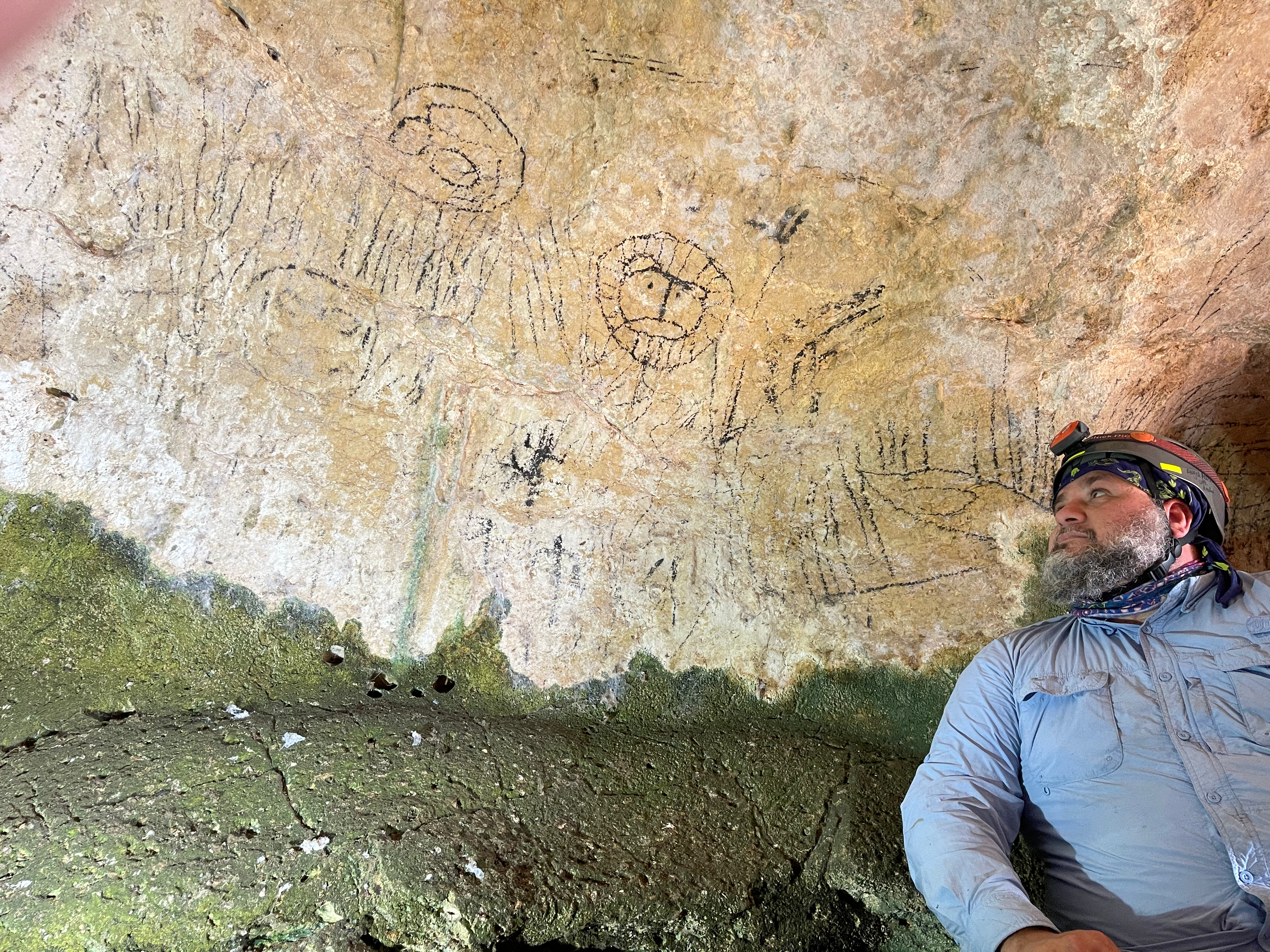 Angel Acosta-Colon poses with a number of pictographs
