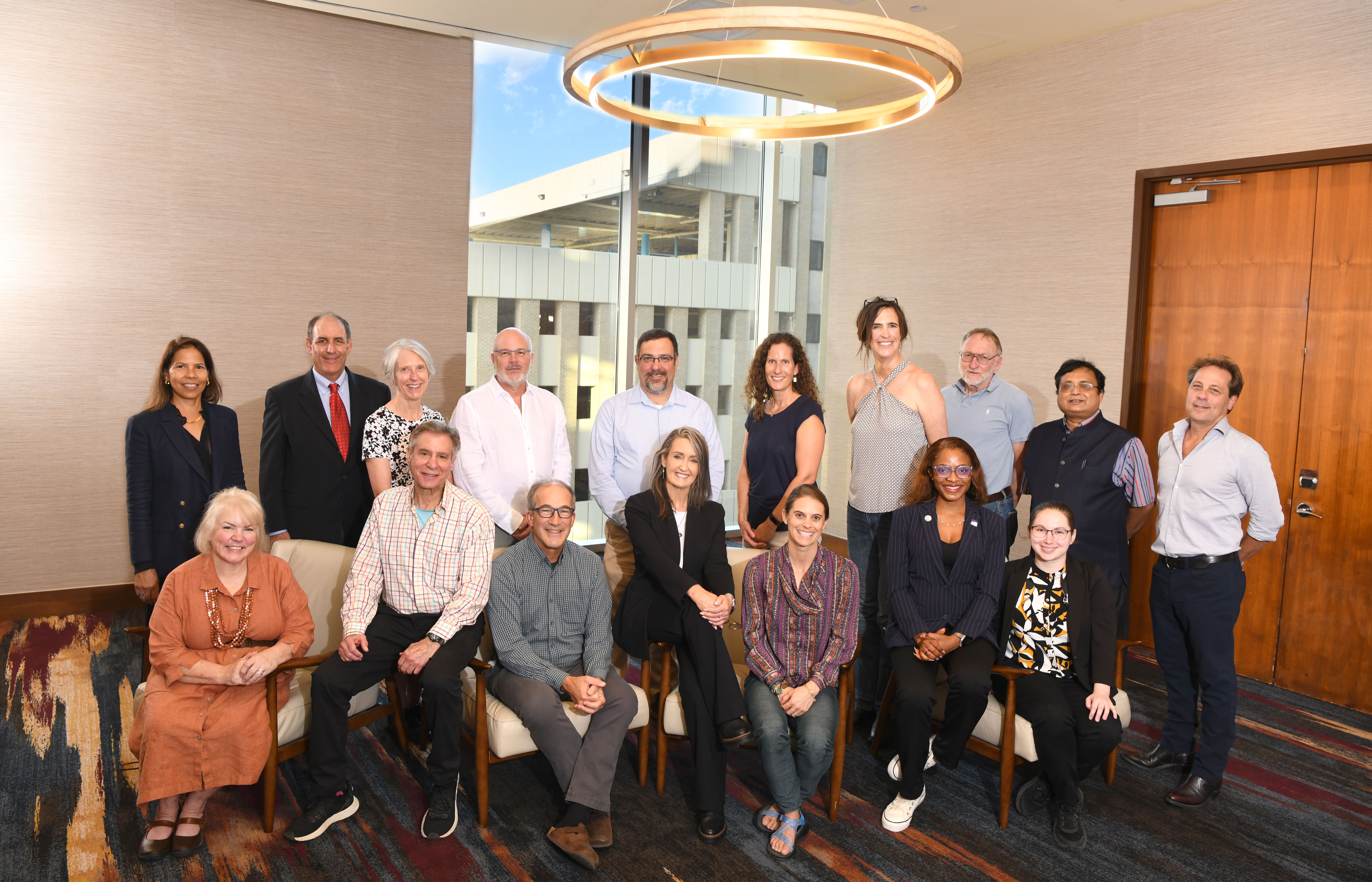 A large group of GSA leadership and council members pose together for a formal group photo in a modern, well-lit conference room during GSA Connects 2025, with some seated in the front row and others standing behind them beneath a circular chandelier.