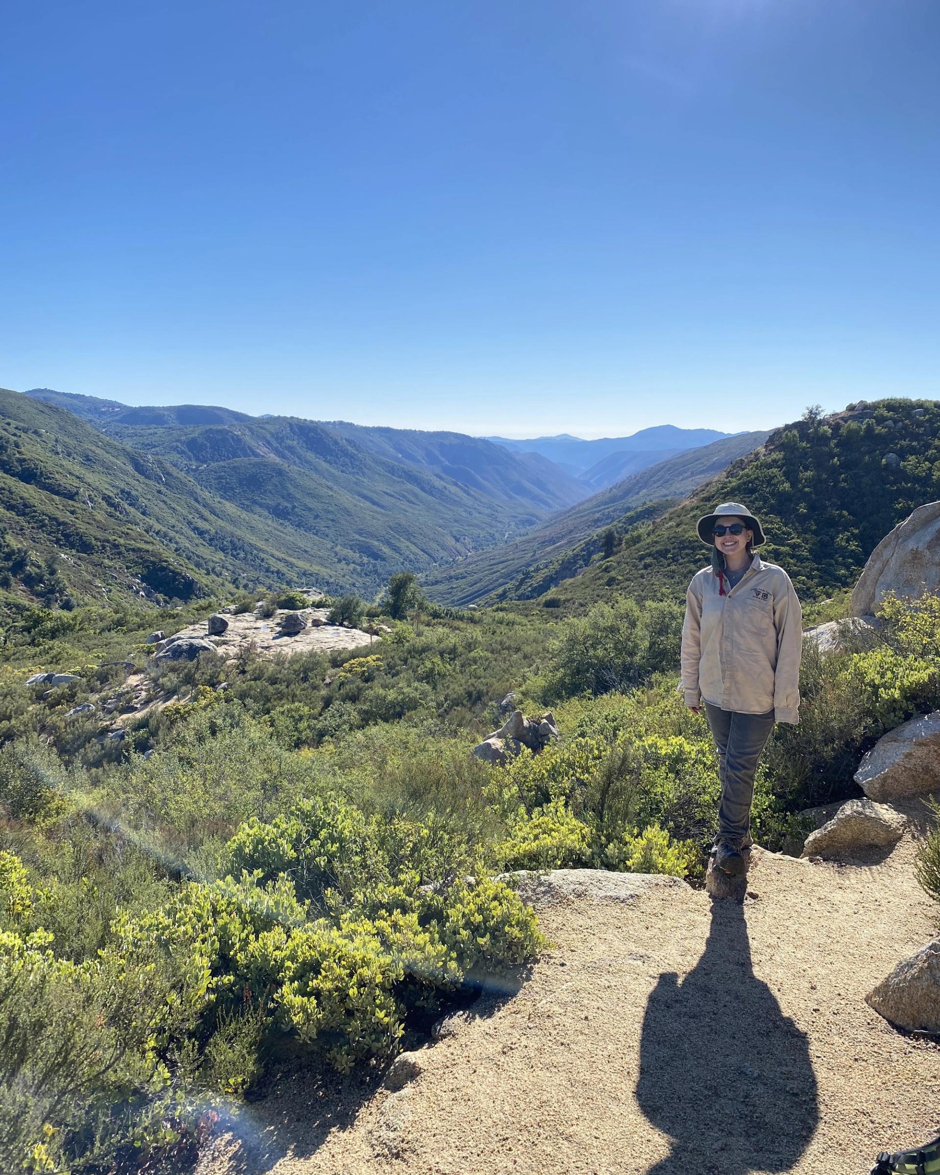 Photo of GeoCorps Participant in the field with mountains in background