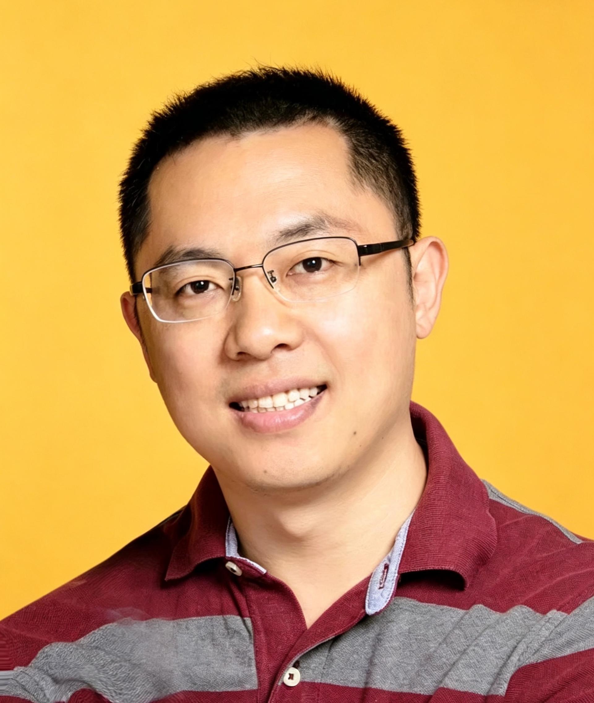 Jiyuan Yin in a red and gray striped collared shirt and against a golden yellow background.