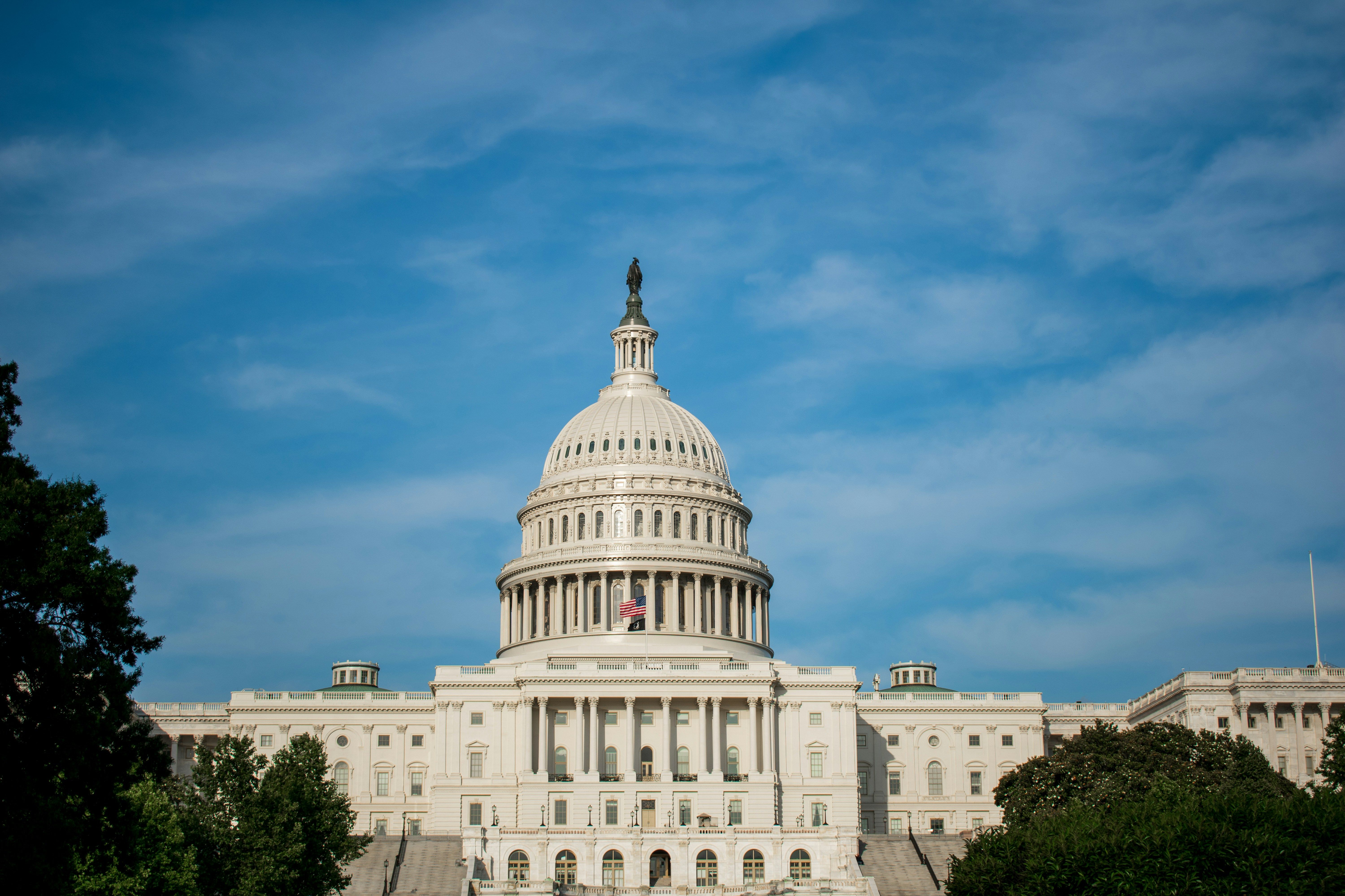 The United States Capitol building under a blue, wispy sky.