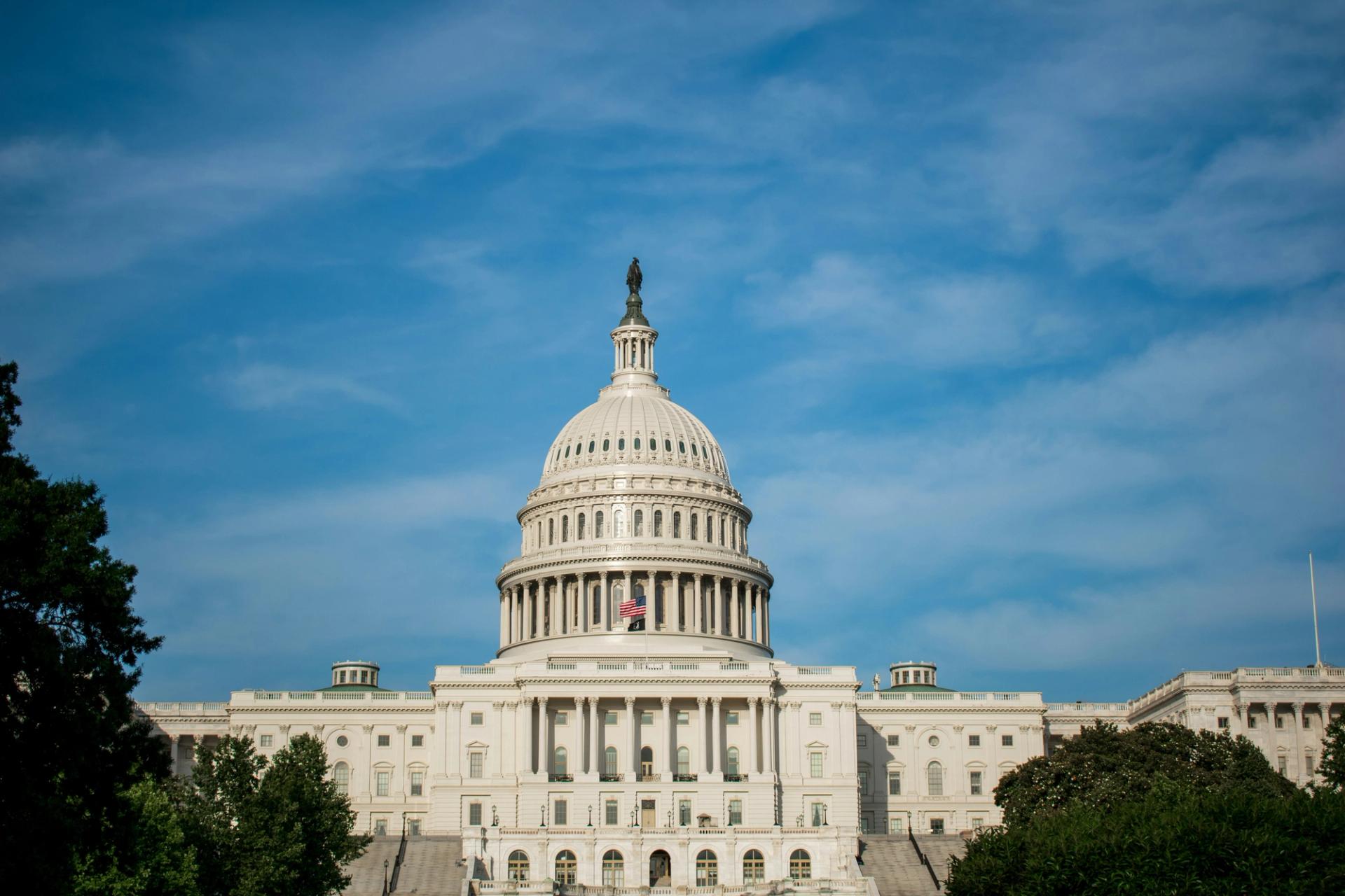 The United States Capitol building under a blue, wispy sky.