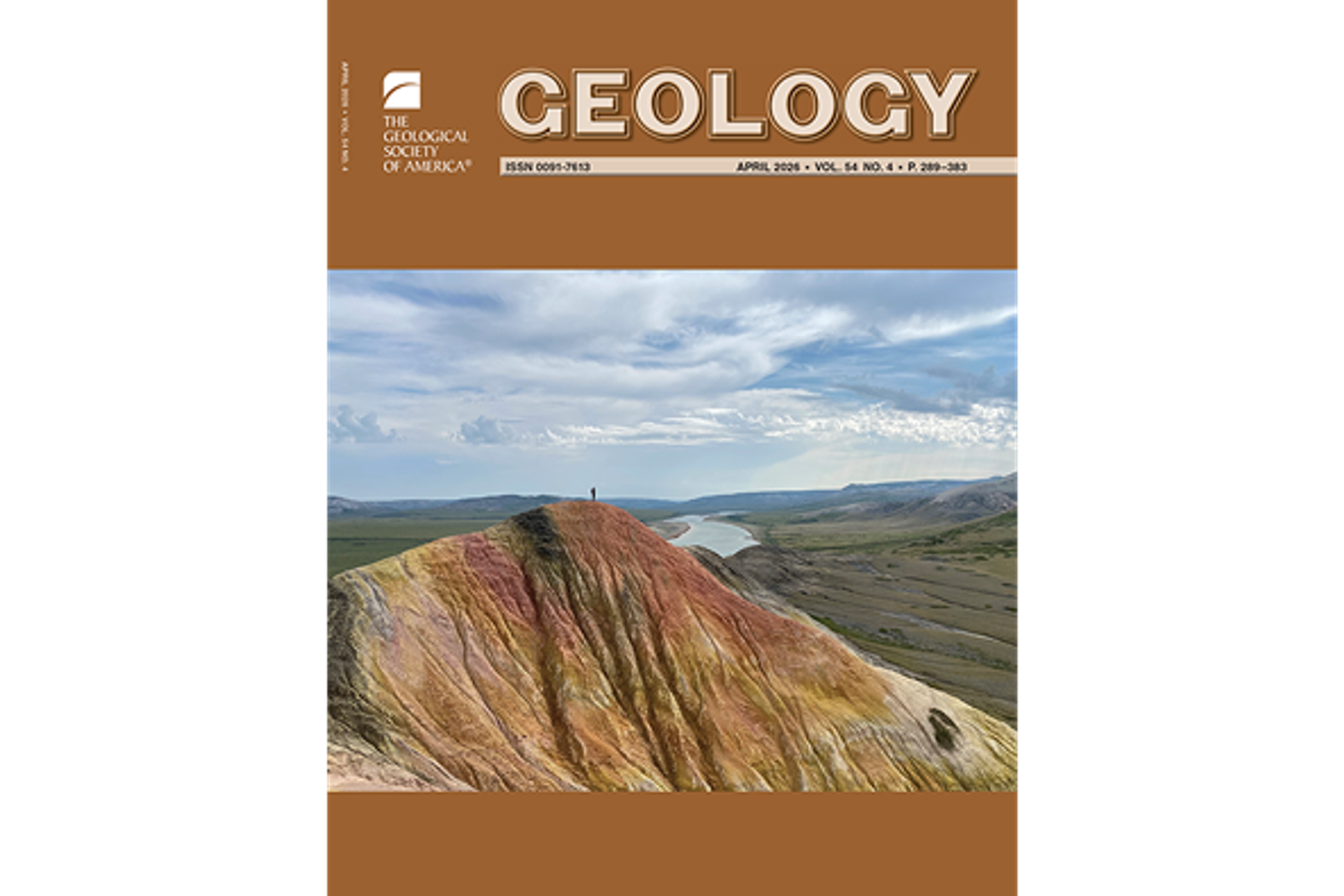 A person at the top of a multi-colored mountain is facing the distant horizon with a river in the middle and a cloudy blue sky. Above and below the image are burnt orange panels of color. The top panel has “Geology” in capital letters, the GSA logo, and issue information.