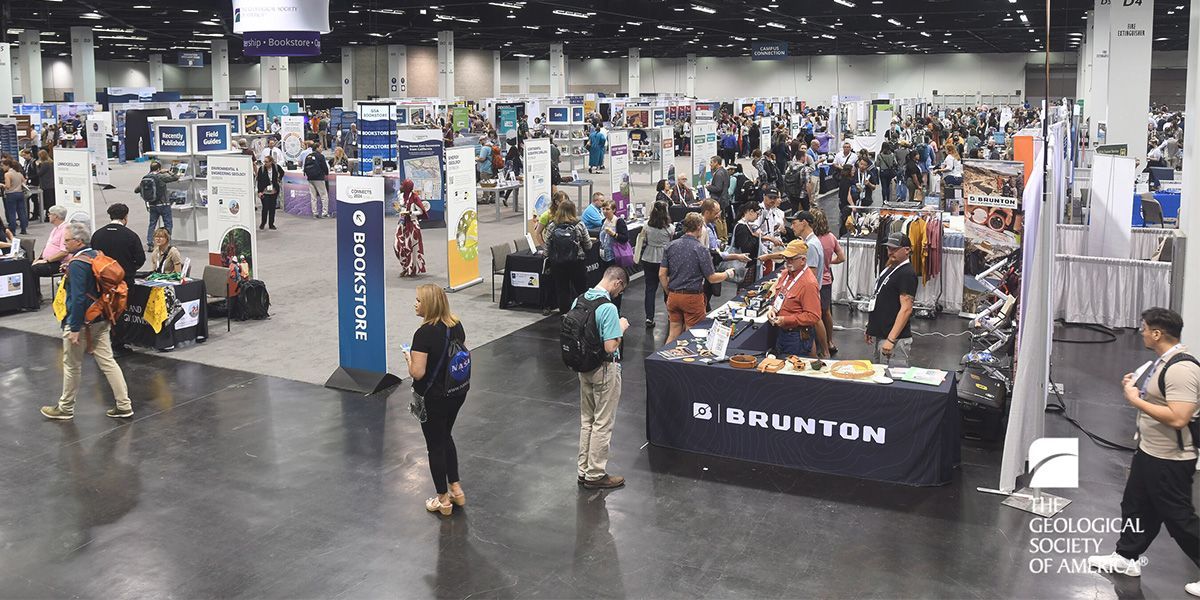 Conference attendees fill an exhibit hall.