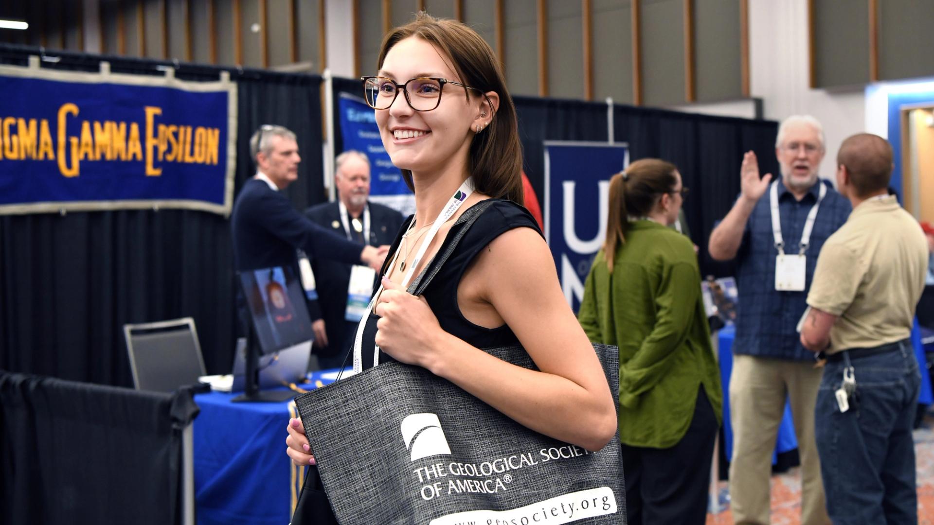 Triple Southeastern North-Central South-Central GSA attendee holding GSA tote bag