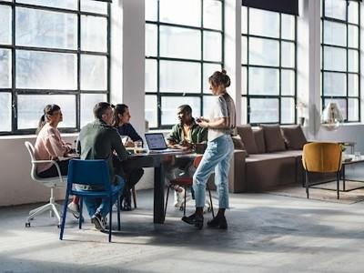 A group of people engaged in conversation in an office.