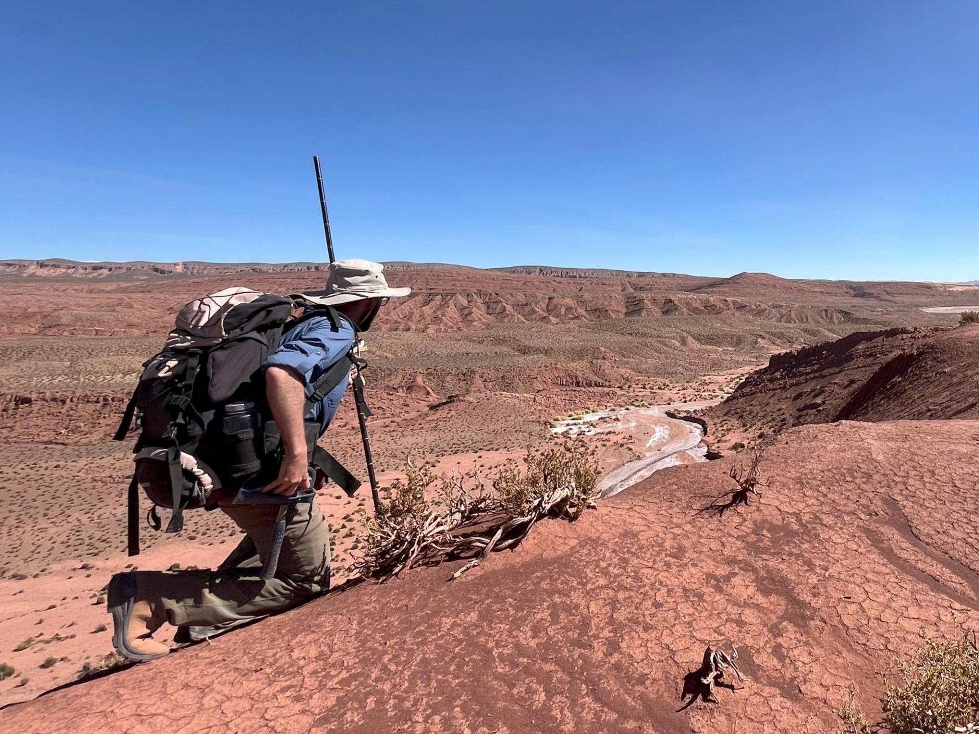 Photo of GSA graduate student research grant recipient conducting geoscience research in the field in red desert