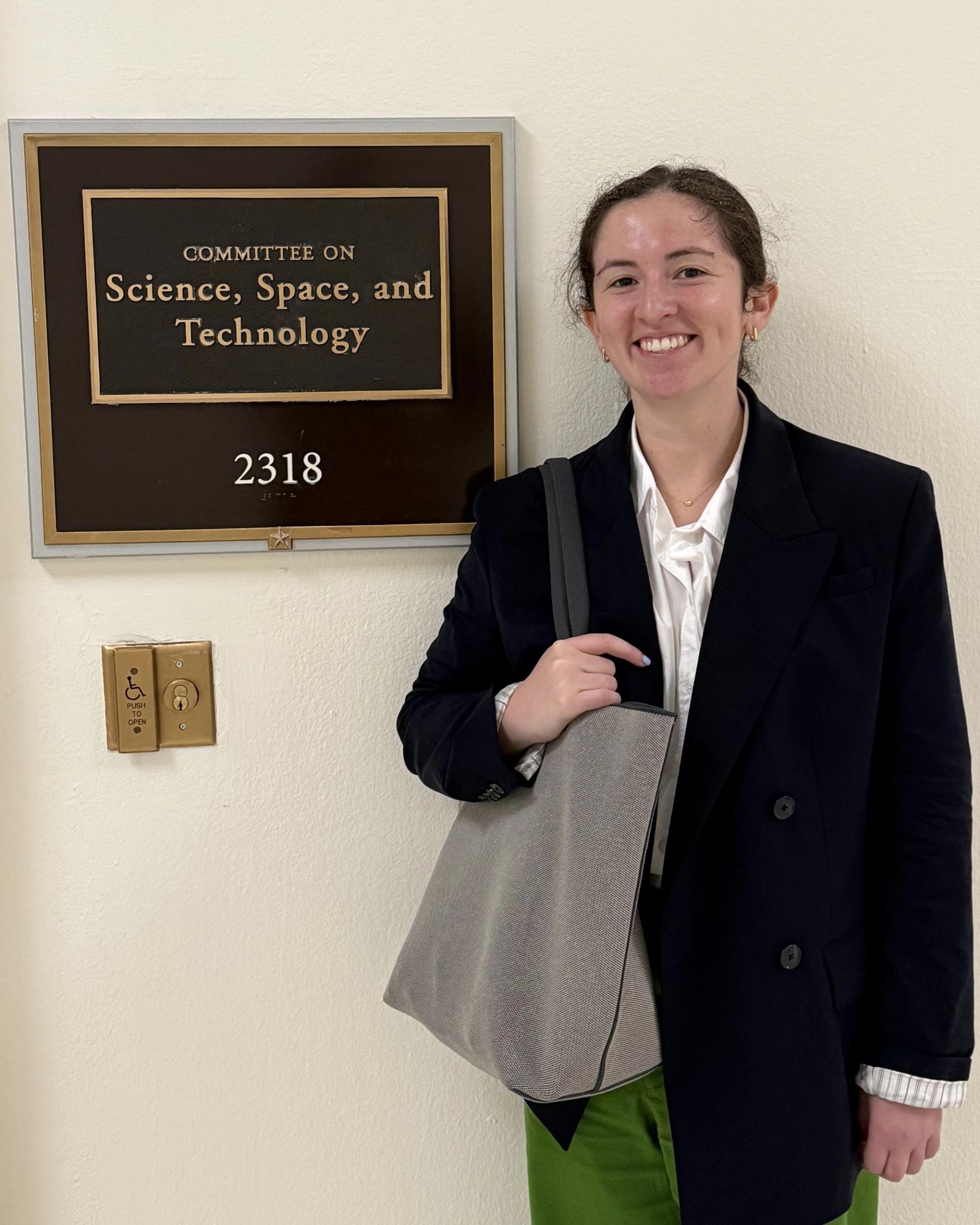 GSA geoscientist posing next to “Science, Space, and Technology” Plaque at Capitol on Congressional Visits Day