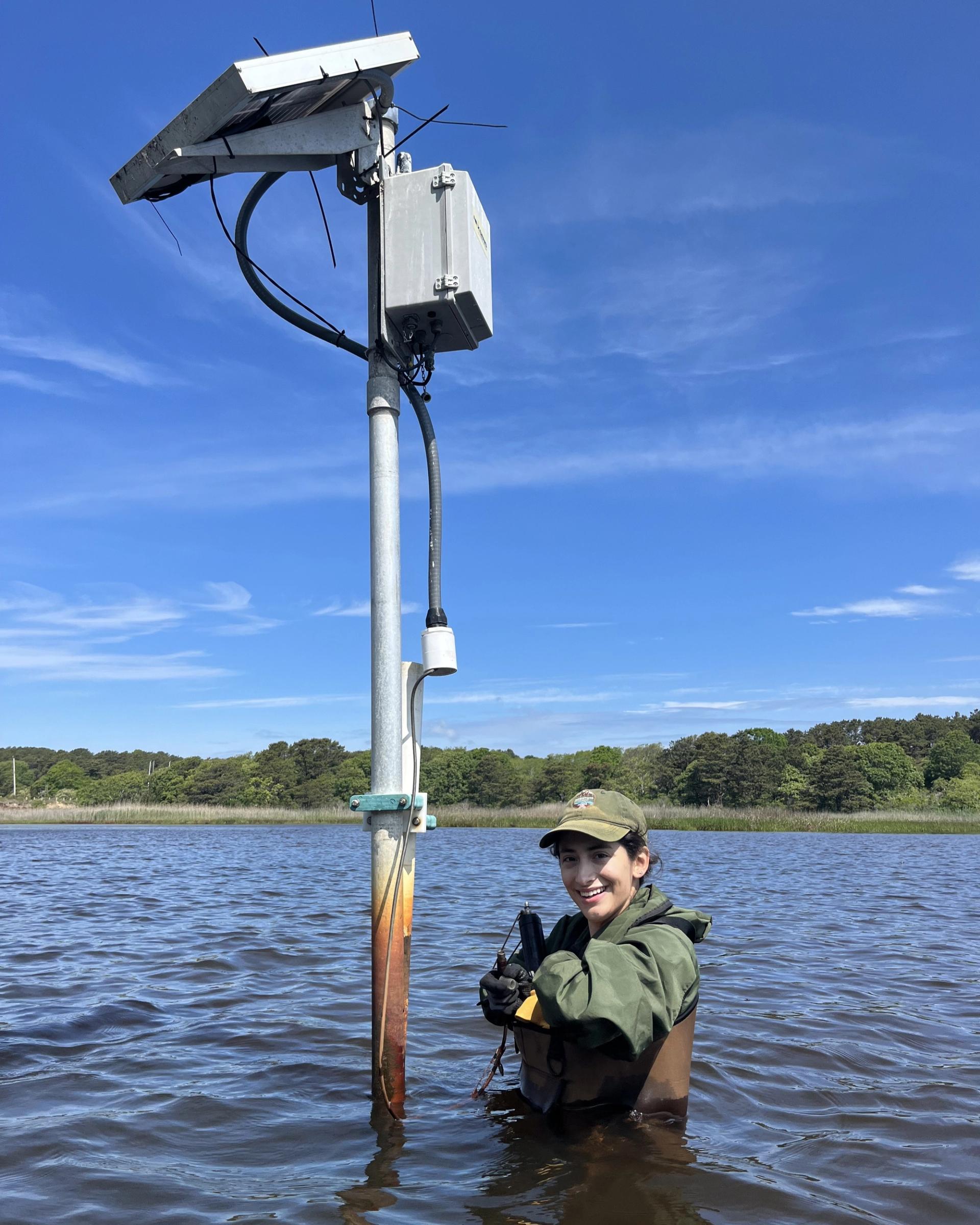 Photo of Scientists in the Parks Participant conducting fieldwork waist deep in a lake taking measurements