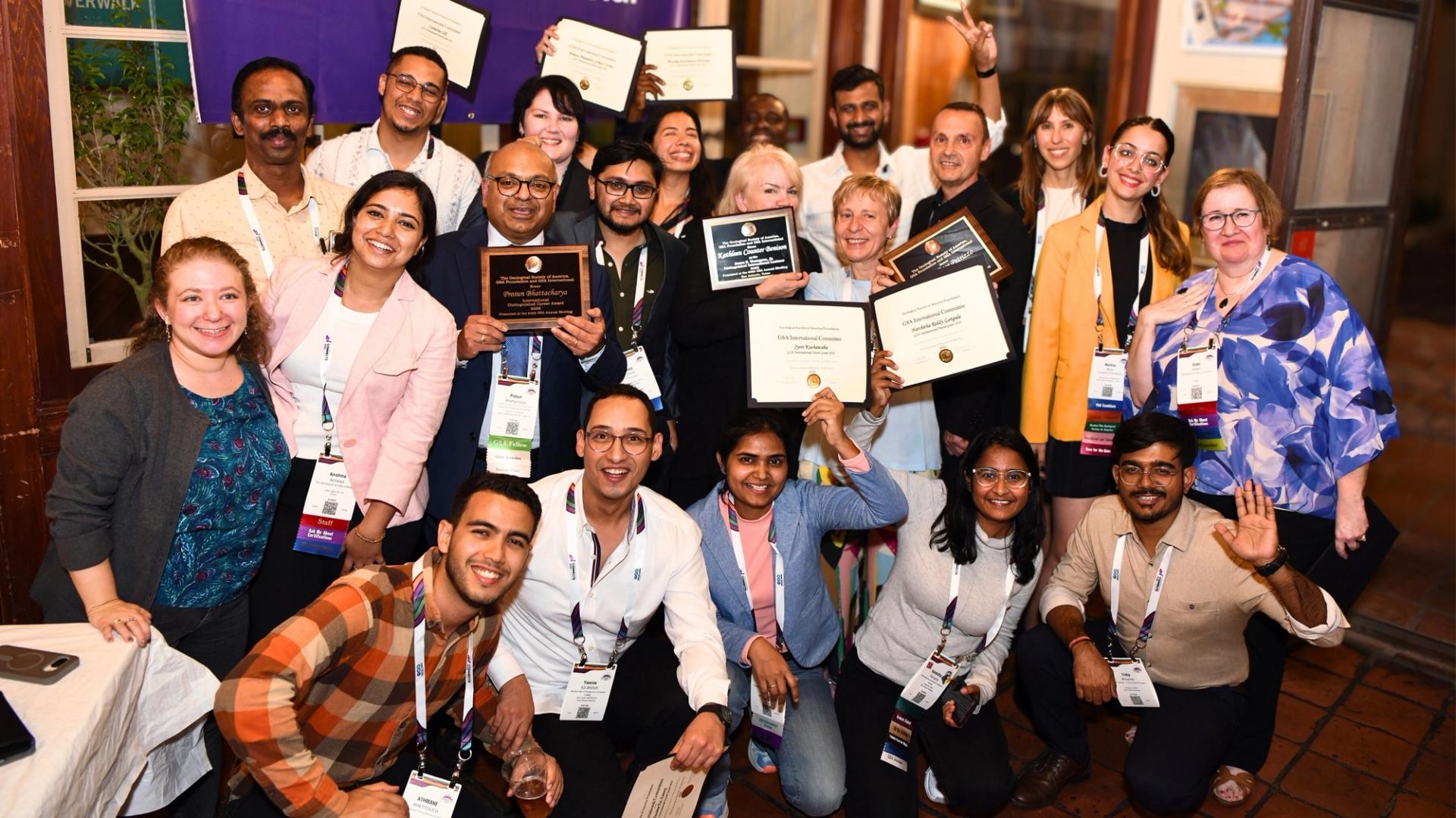 International travel grant and award recipients holding up award certificates at GSA international reception