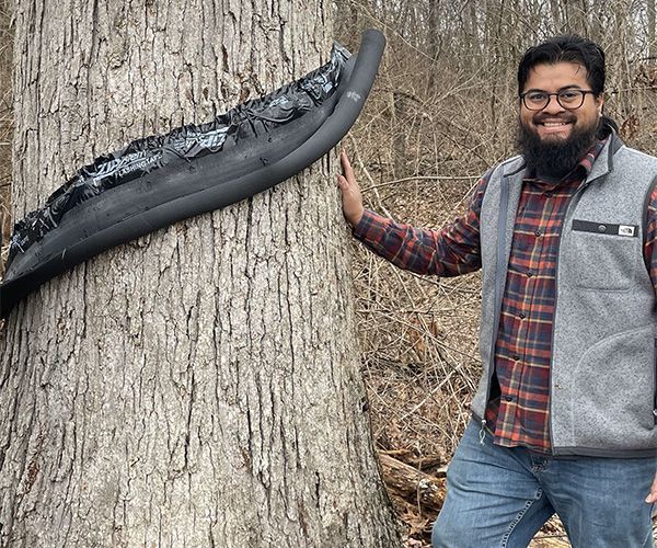Graduate Student Research Grant recipient Jorge Vera conducting field work for his project: "This image shows our stemflow collection double helix made out of pipe insulation."