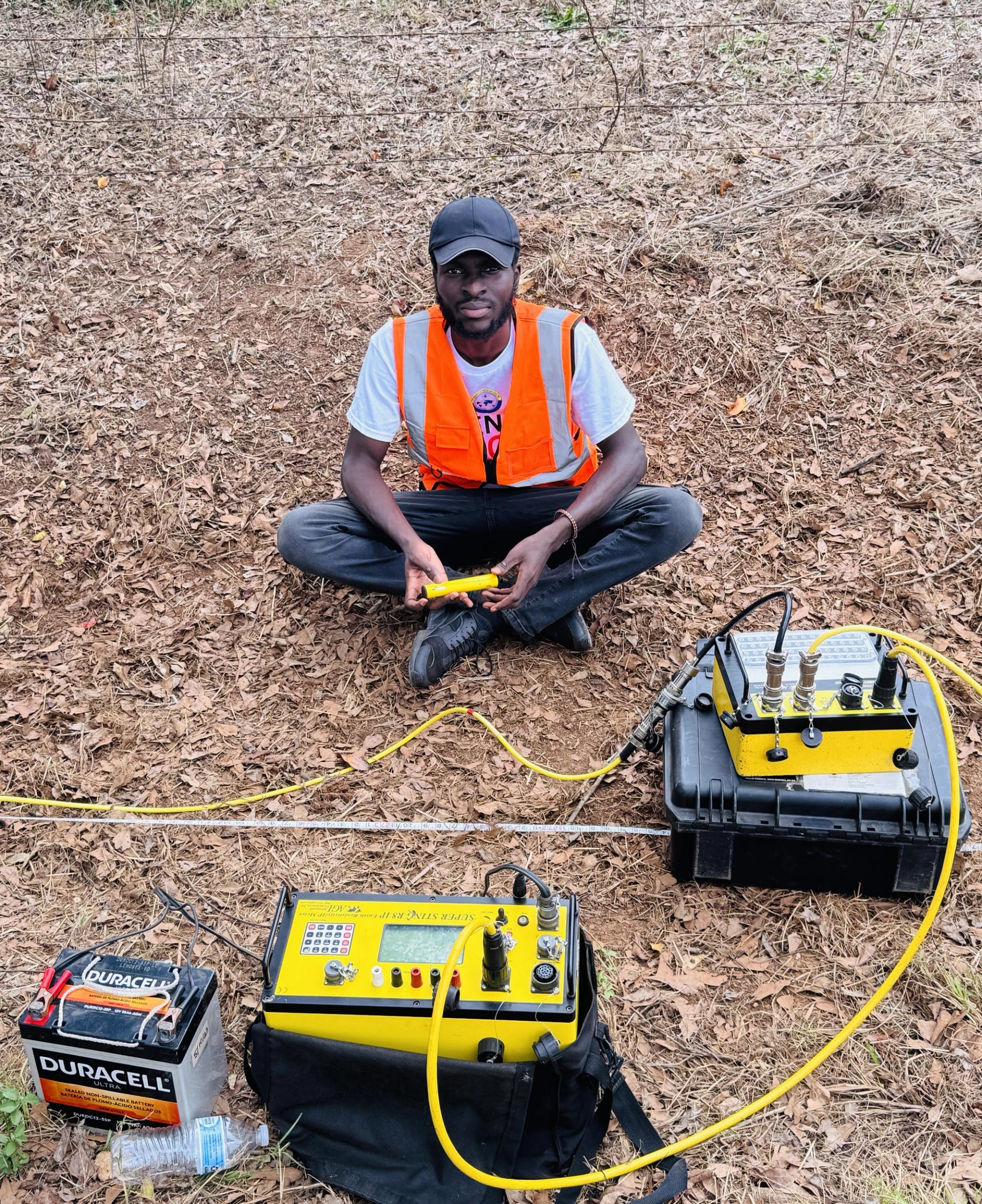 Kwaku Asiedu, a geophysicist or researcher, conducting an Electrical Resistivity Tomography (ERT) survey.
