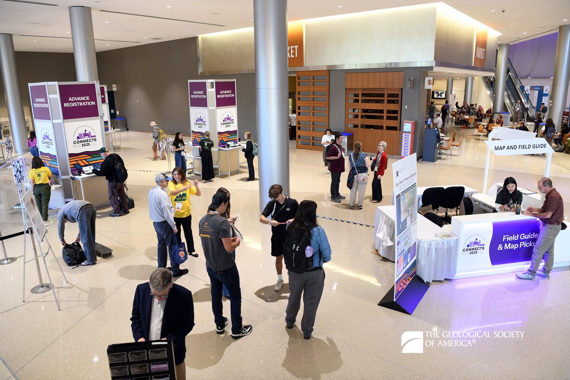 Conference attendees check in at registration kiosks.